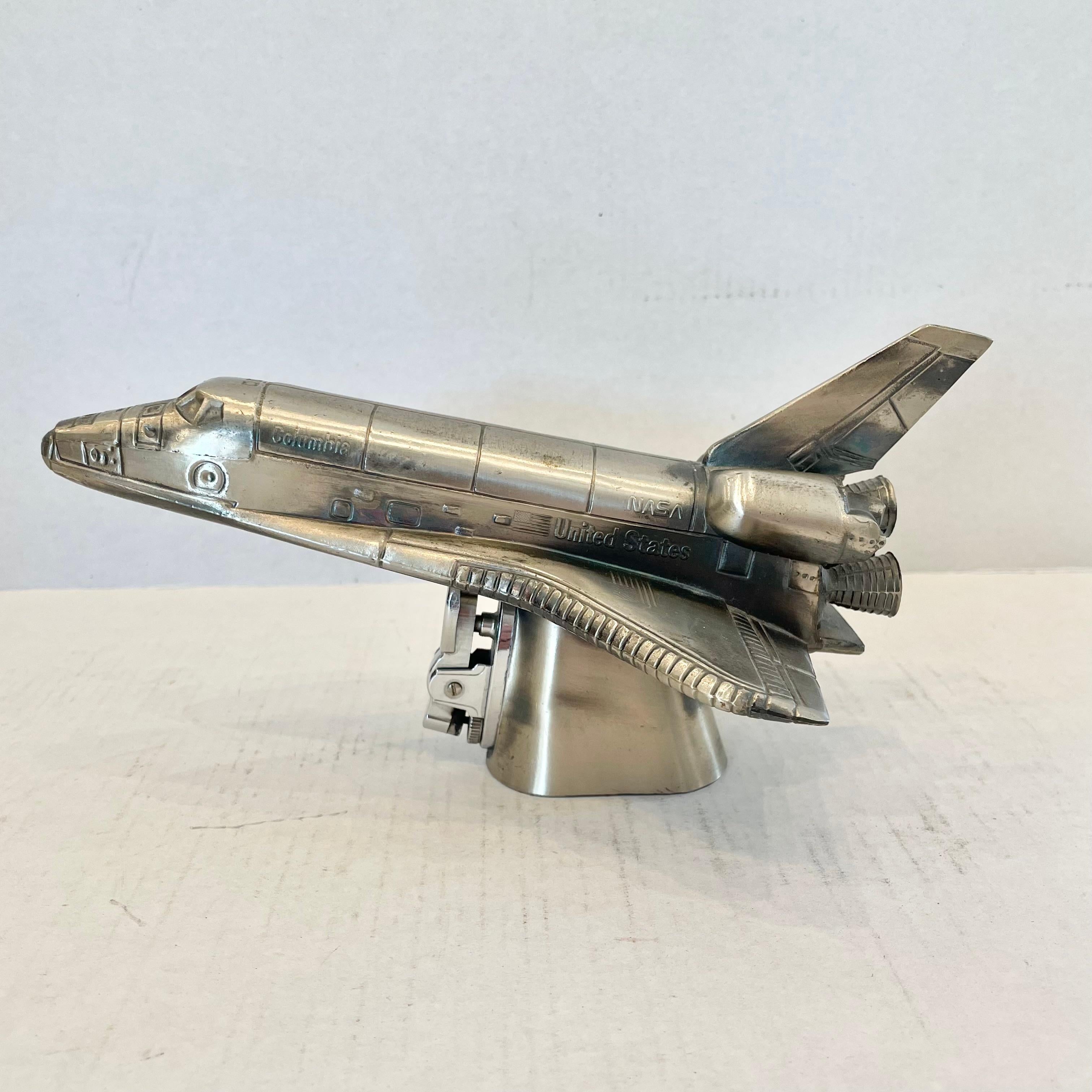 Cool vintage table lighter in the shape of a Nasa space shuttle. Made in Japan, 1980s. This piece has great balance and details. Cool tobacco accessory and conversation piece. Working lighter. Good vintage condition.