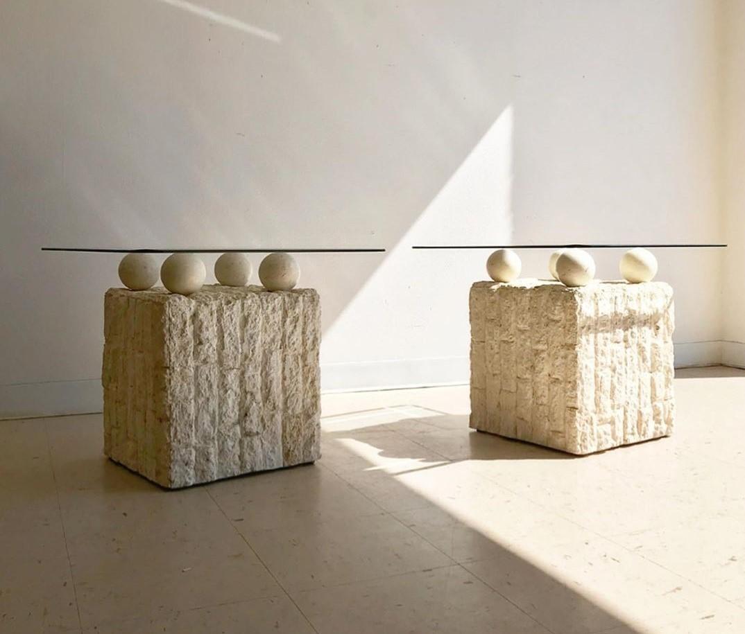 Unique Postmodern 1980s design, freeform end/side tables. Each table base in rough edged brick motif Mactan stone. Four stone balls holding the removable circular glass tops. Can be used both indoors and outdoors. 

Measured with glass top: 21.5