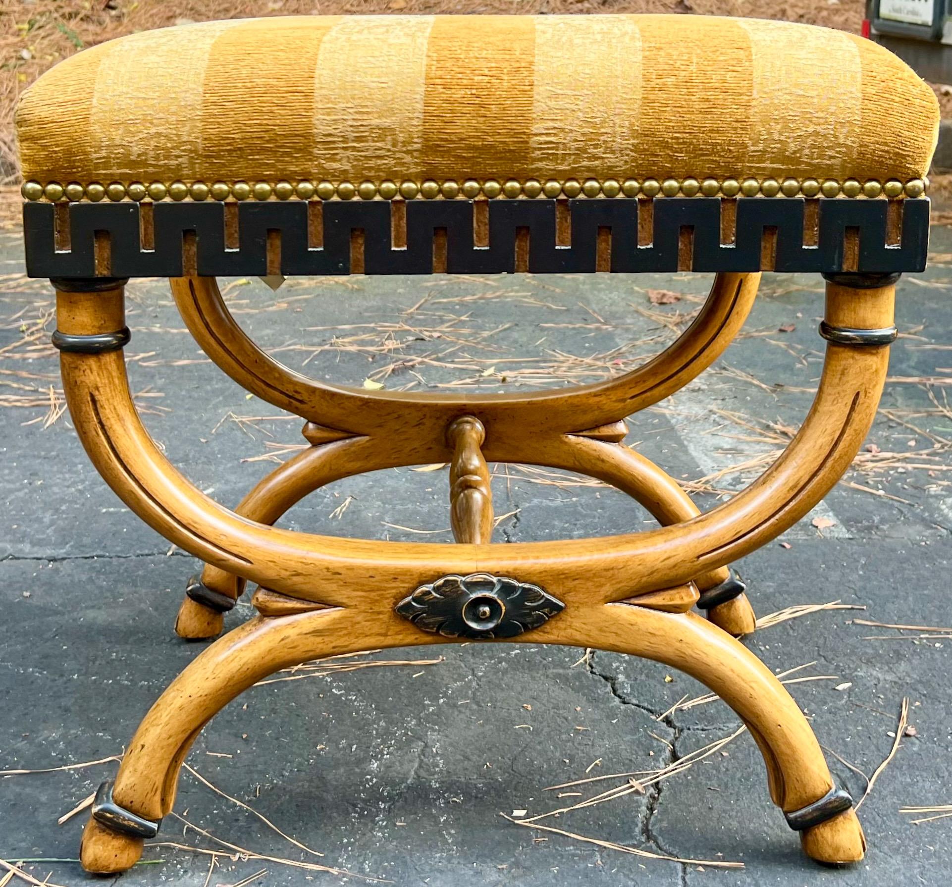 I love these! This is a pair of carved fruitwood ottomans with neo-classical styling. Note the ebonized Greek Key detailing and hoof form feet. The vintage upholstery is in good condition. They are marked. Lite wear.