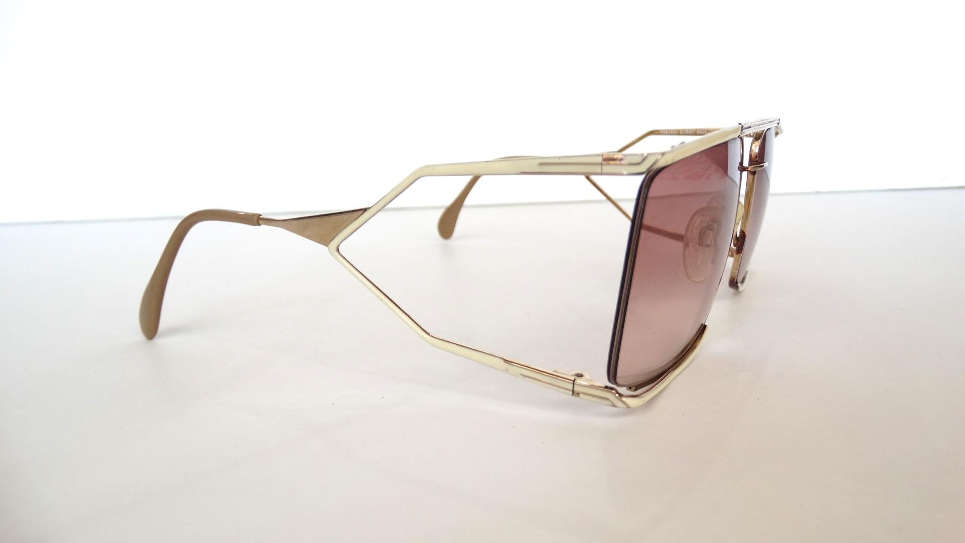Elevate Your Look With These Amazing Sunglasses! Circa 1980s, these oversized sunglasses are designed by the iconic 60s brand Neostyle. Features silver hardware and a painted white outer frame. Small silver accent lines are featured on the sides of
