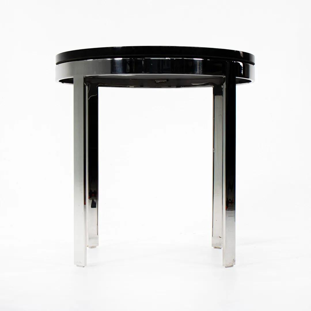 This is a black marble and stainless steel side table designed by Nicos Zographos and produced by Zographos Designs Limited. Zographos is known for his exquisite metal furniture. 
 
The piece measures 19 inches in diameter, and is 18.5 inches tall.