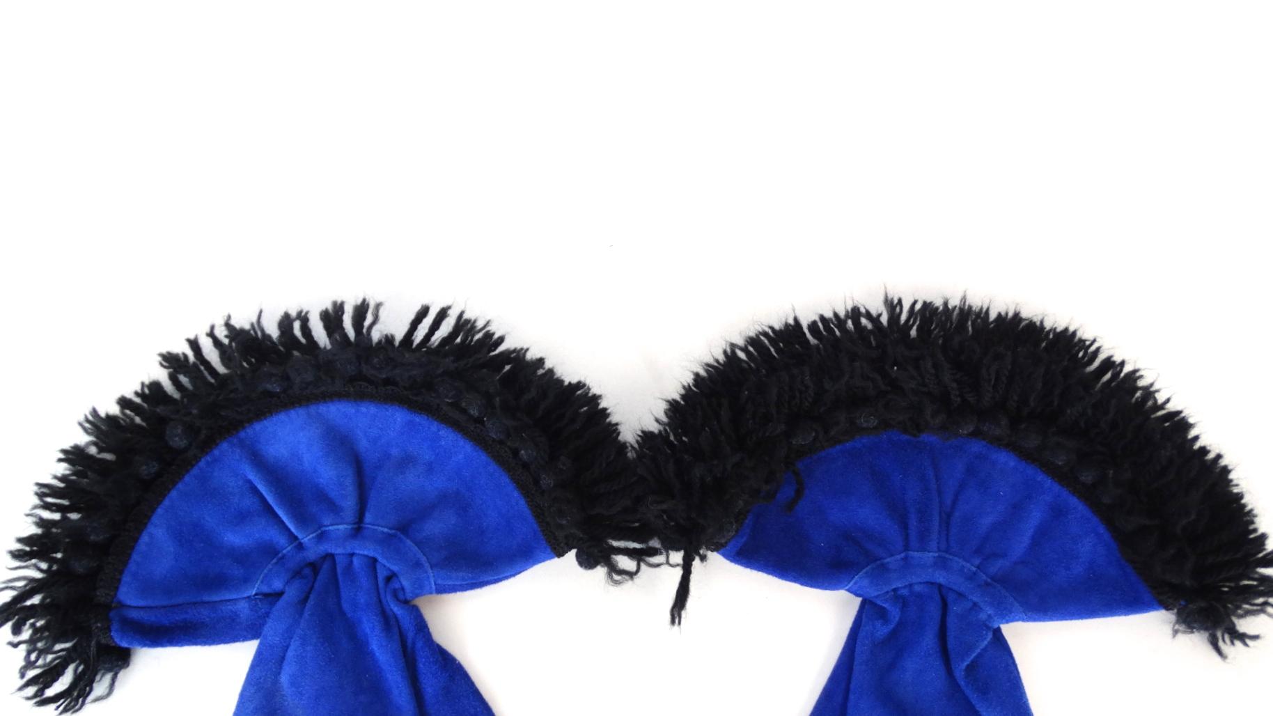Stay Stylish During The Fall/Winter Seasons With These Amazing Gloves! Circa 1980s, these suede gauntlet style gloves are a beautiful royal blue color. Features a decorative trim made of black yarn. An elastic band cinches at the wrist for a