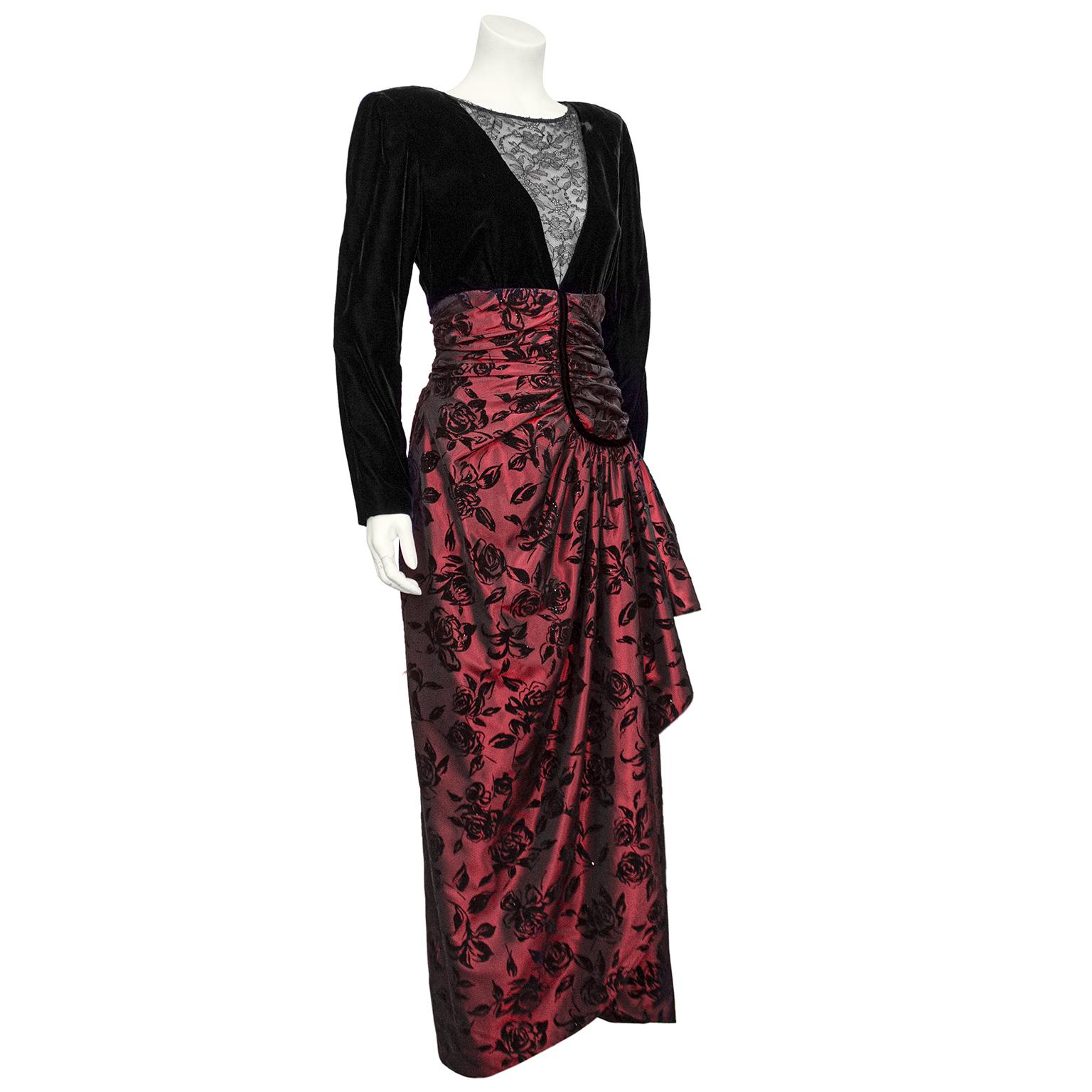 Over the top fabulous Nina Ricci gown from the 1980s. Top is cut black velvet with gathering at padded shoulders and a deep V-neckline inset with elegant black lace. The red silk taffeta skirt with all over black velvet roses starts just under bust