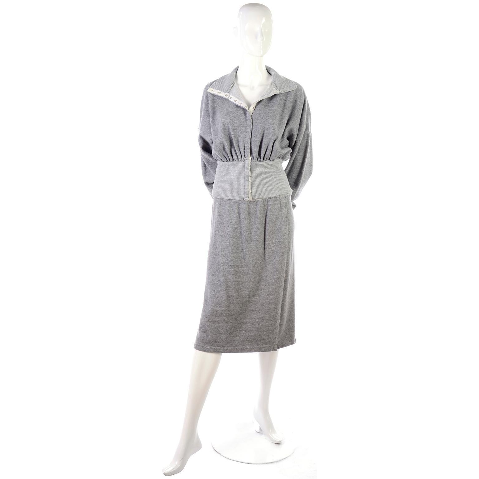 This is an iconic outfit in an extremely soft heathered gray cotton iconic sweatshirt material  by Norma Kamali. The skirt has an elastic band at the waist and high hip, and a slight front wrap that closes with snaps in the front. The snaps can be