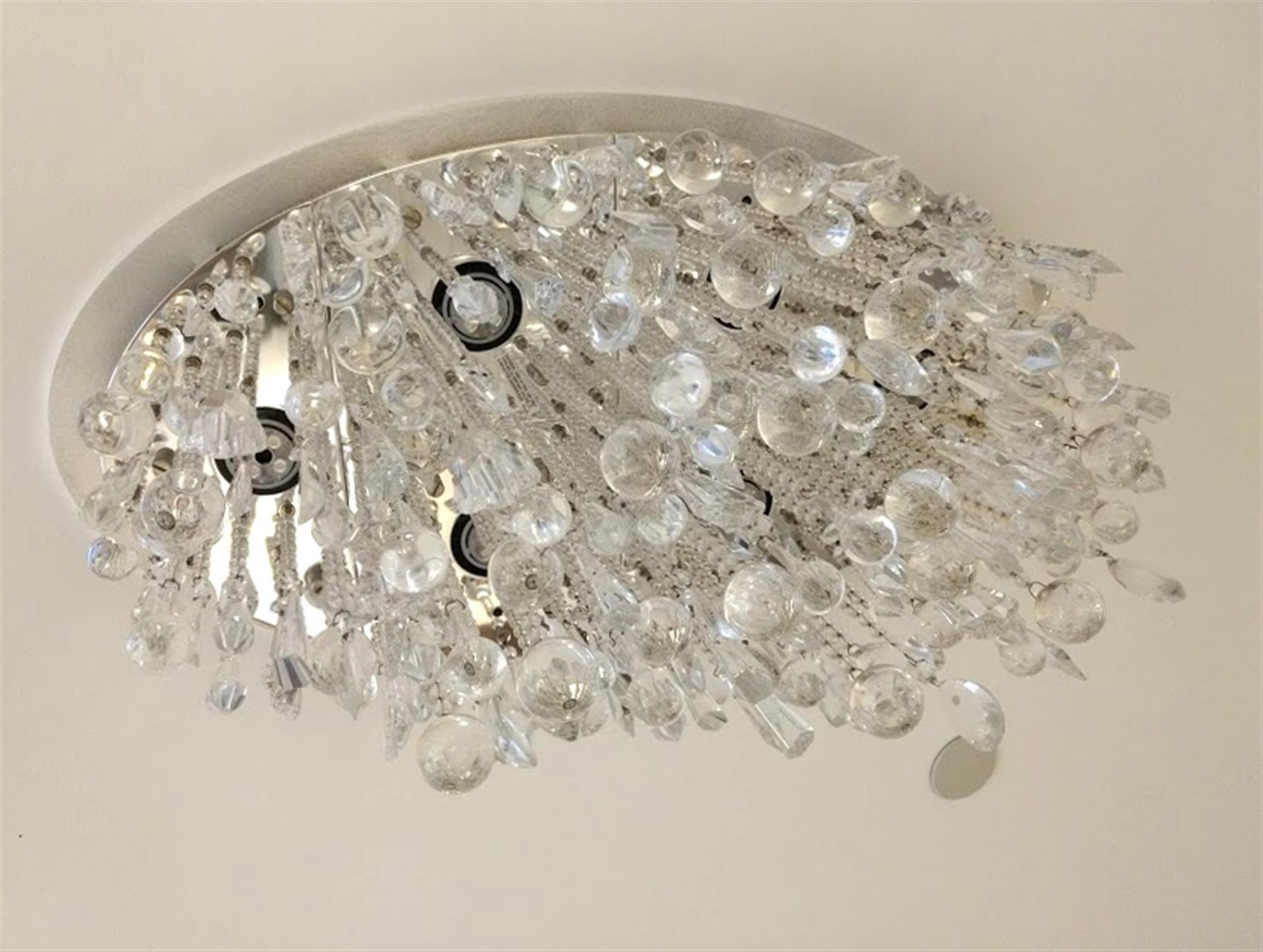 NYC Waldorf Astoria Hotel flush mount ceiling fixture with crystal pendeloques and prisms that drape from an oval satin nickel mesh frame by designer Todd Rugee. Retrieved from the 19th floor health spa in the Waldorf Astoria during the most recent