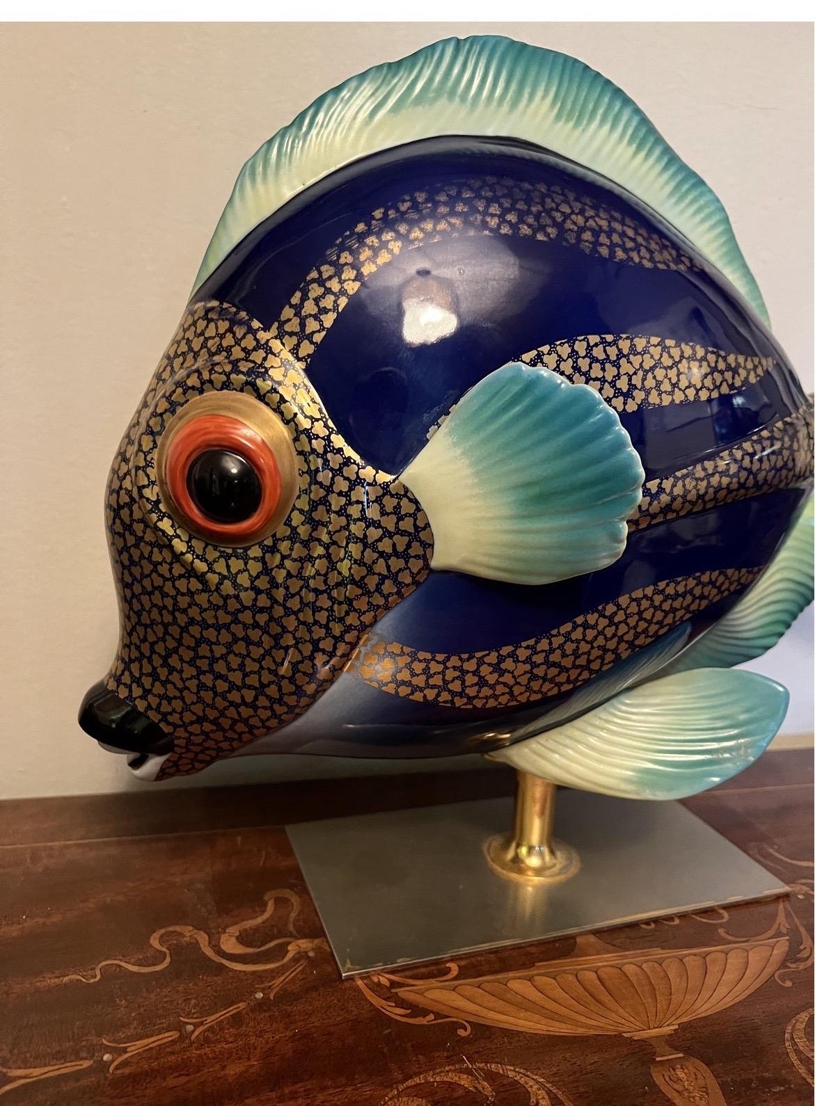 A vintage hand painted porcelain fish sculpture by Oggetti. Superb detail and real life size! 
This porcelain “Mangani” fish is decorated with gilt details, hand painted body and mounted to a custom brass base / stand.