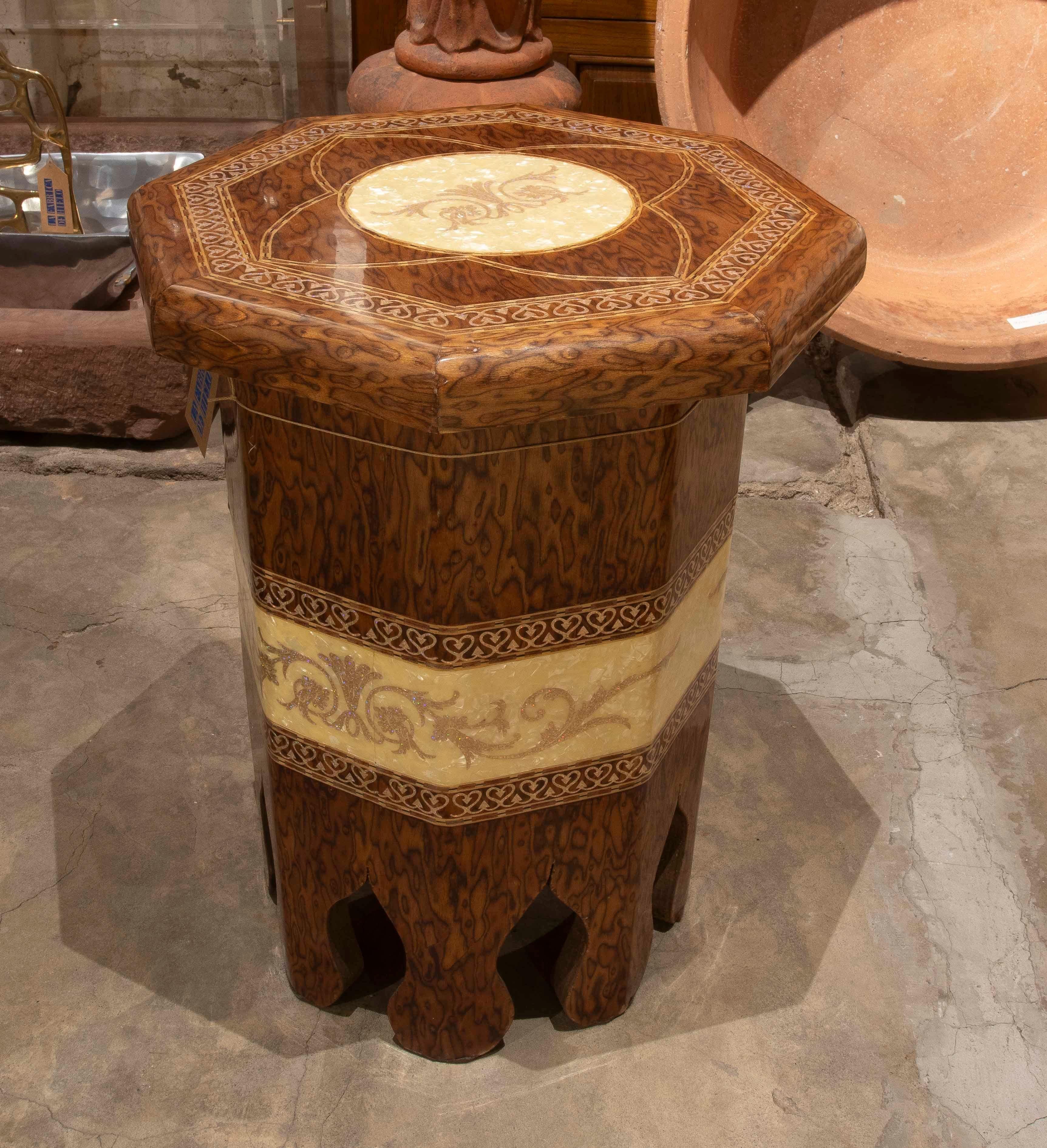 A sophisticated octagonal side table or pedestal, crafted with elegant wood and resin work. The surface features a cream-toned circular central design with decorative floral motifs, surrounded by a delicate intertwined geometric border.

The base