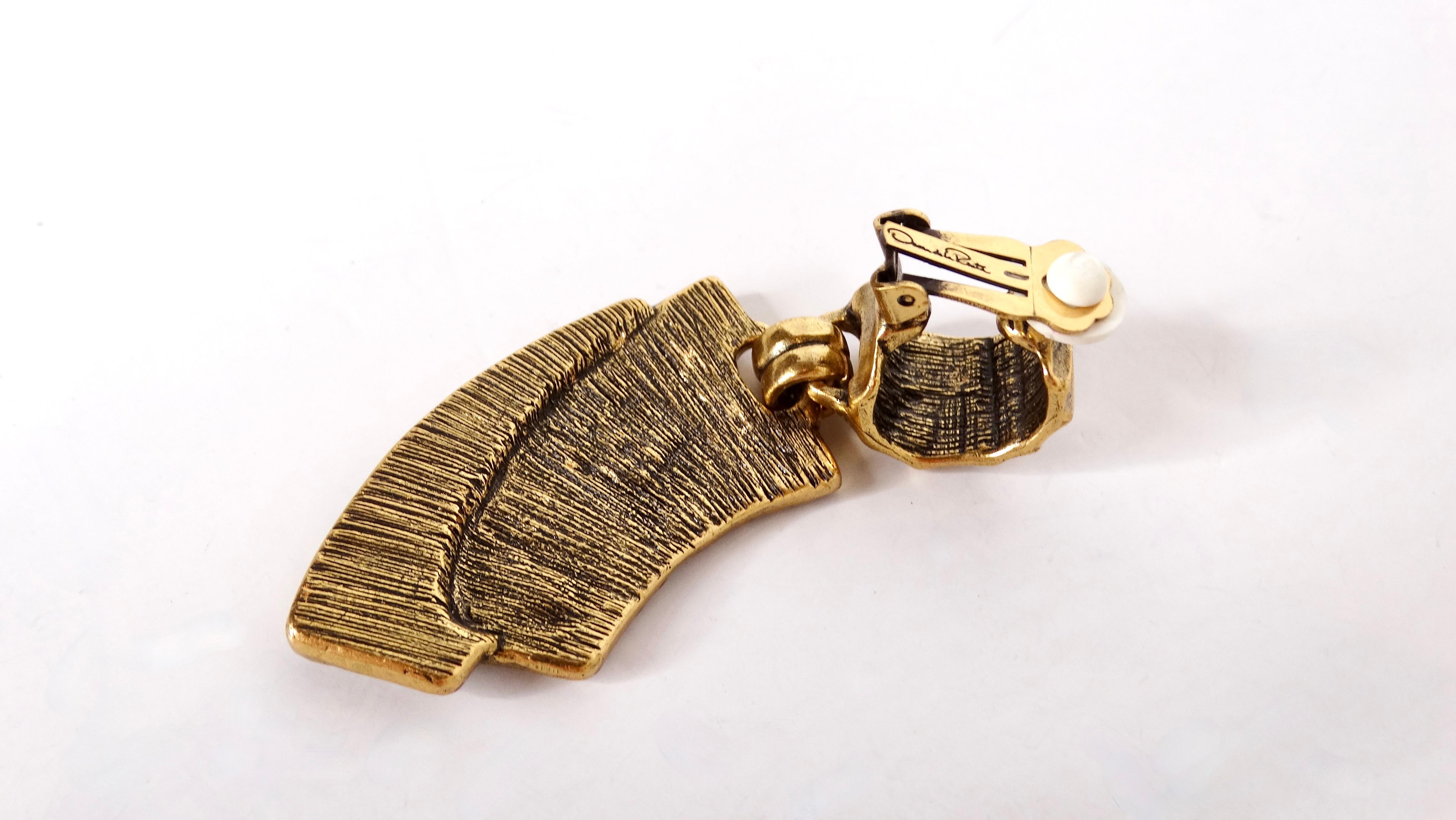 Step into the world of vintage luxury with these stunning 1980s Oscar De La Renta 18k Gold Plated Geometric Statement Clip-On Earrings. These crescent-shaped earrings are a bold statement piece, showcasing an antique-inspired design that exudes