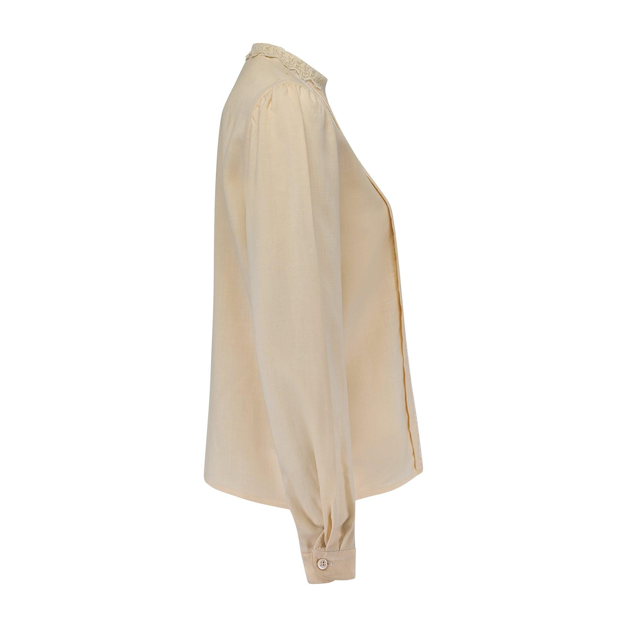 This late 1970s to early 1980s Oscar de la Renta Victoriana blouse is tailored from rich cream-hued muslin in a straight-cut silhouette. Detailed with machined, white filet lace; the collar is formed from cream lace with a scallop hem. The shirt