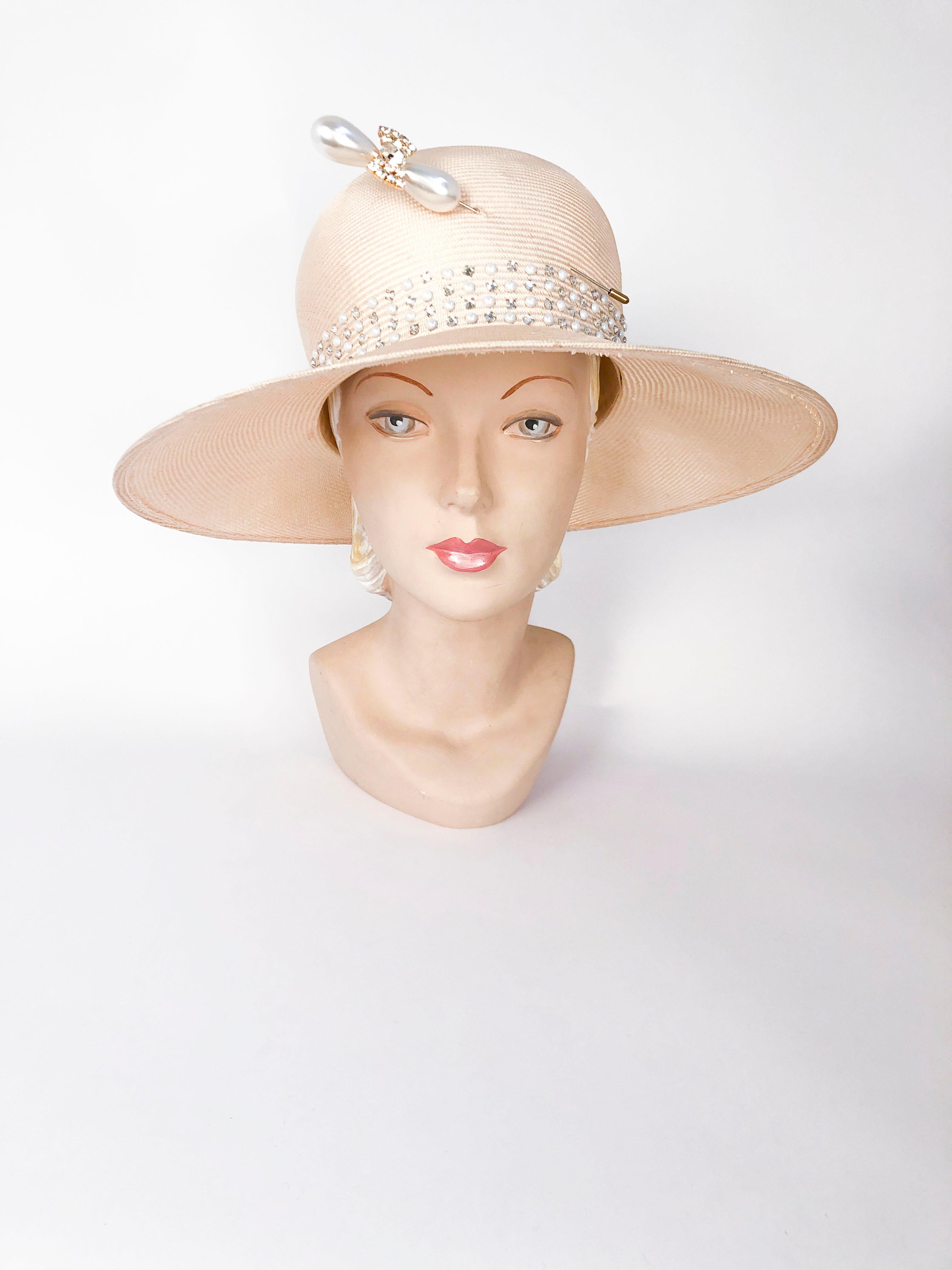 1980's Straw wide-brim sun hat with pearl and rhinestone accents and a large decorative hat pin.

22 inch interior circumference.