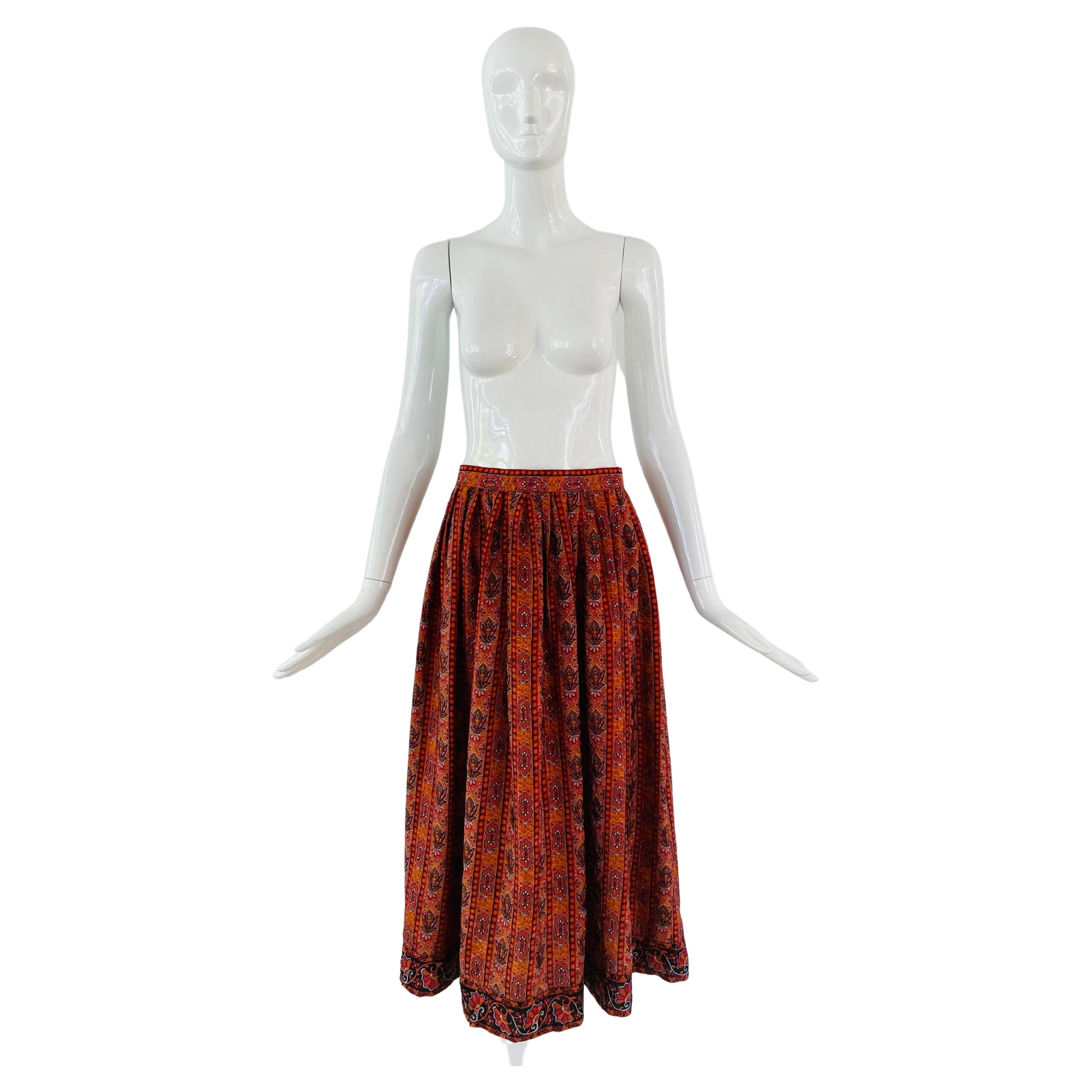 1980s Oscar de la Renta 'Miss O' label midi skirt in flowy and full silk skirt in an Eastern European traditional floral print in vertical lines.  The silk print is done with vibrant colors of orange red and teal. Fitted with a band at the waist and