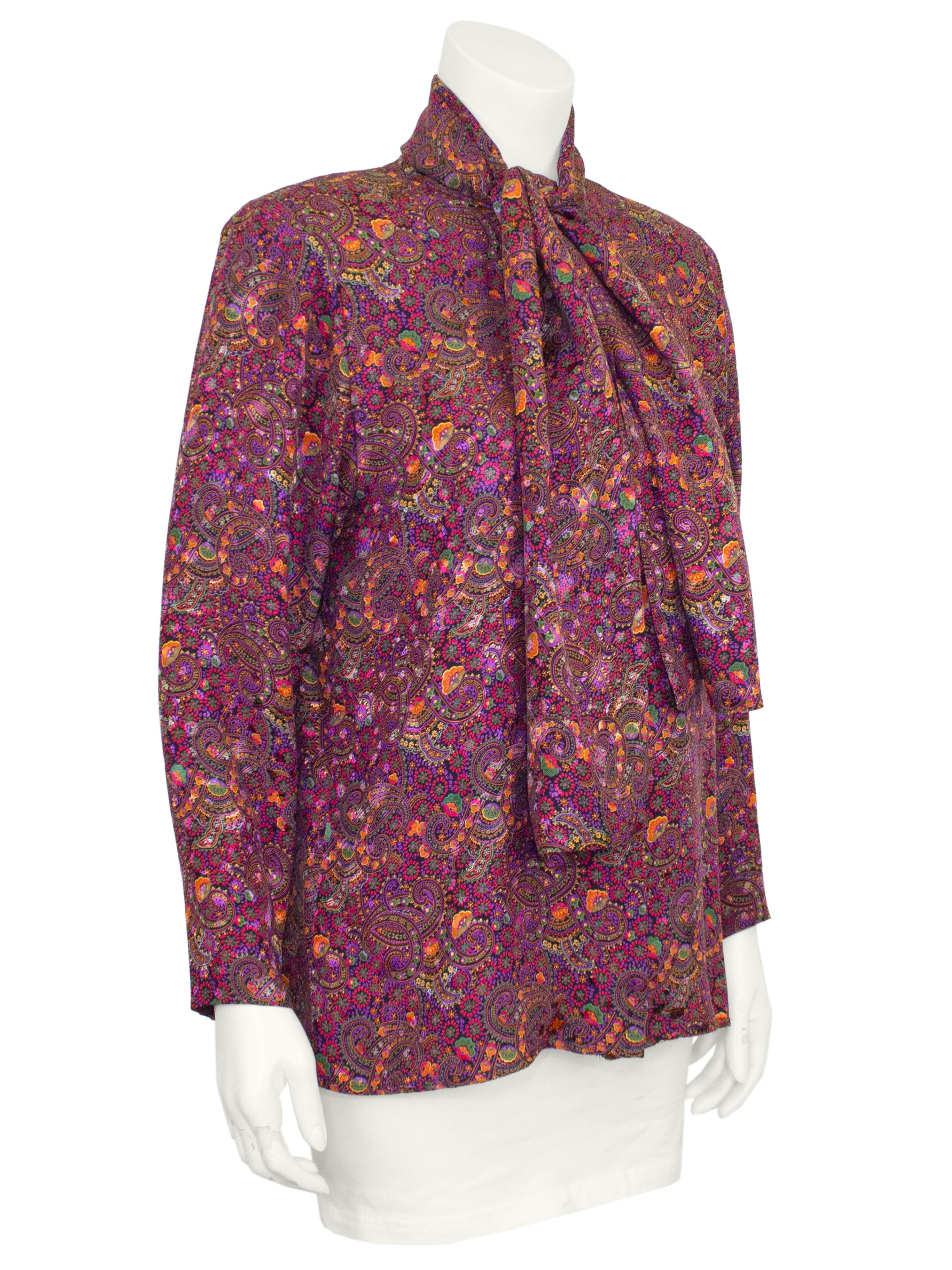 1980s Oscar de la Renta pink and purple paisley printed silk blouse with bow neckline. Buttons down the front with a covered placket, fabric covered black buttons on the cuffs and ties at the neck. Shoulder pads, fits like a US 2/4. 

Shoulder 15