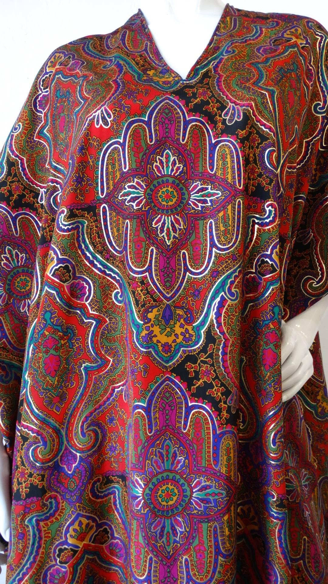 Get groovy in this amazing 1980s does 70s Oscar De La Renta for Swirl caftan! Printed with an amazing Moroccan inspired psychedelic print in shades of red, gold and violet. Loose, flowing caftan fit with maxi length and short sleeves. The perfect