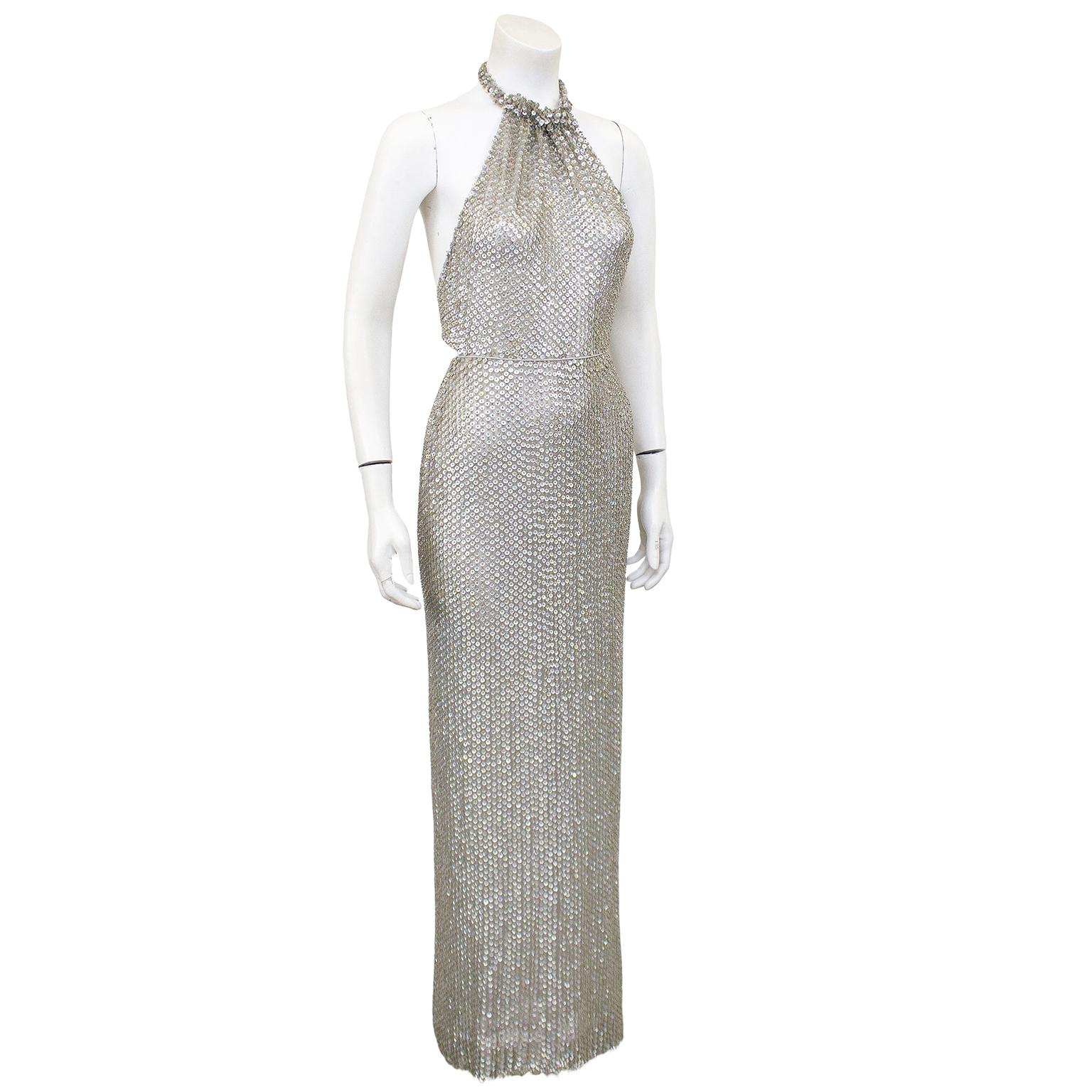 Show stopping silver sequin on chiffon Oscar de la Renta gown from the 1980s. Features a twisted halter neckline and an open back with a thin tie closure. Super sexy, skims the body beautifully. In excellent vintage condition, all original sequins