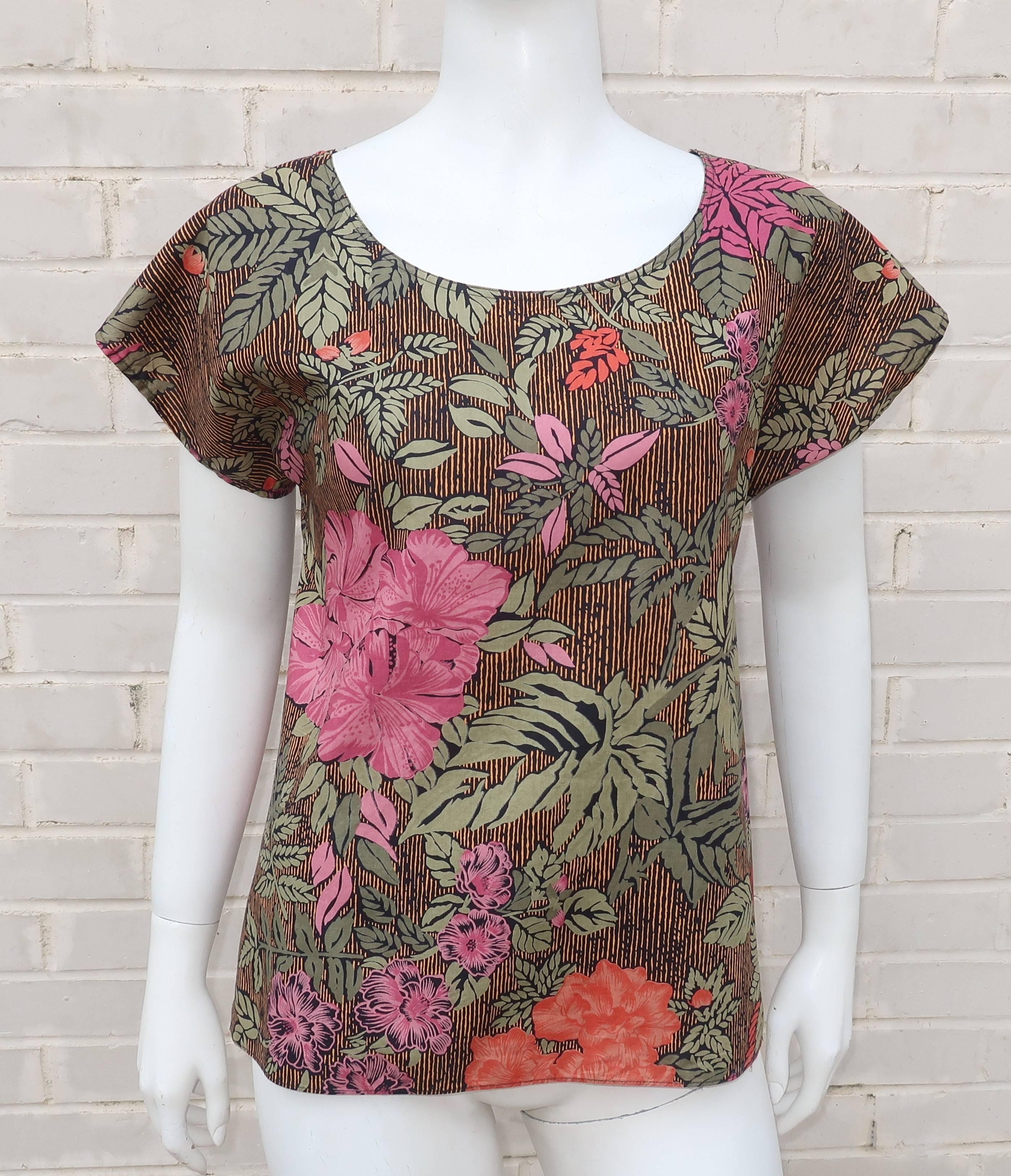 This Oscar de la Renta Sport top is a dark tropical floral pattern incorporating shades of pink, coral red, greens, black and a golden yellow.  The pullover style is easy to wear with short sleeves and a loose silhouette.   Perfect to pair with a