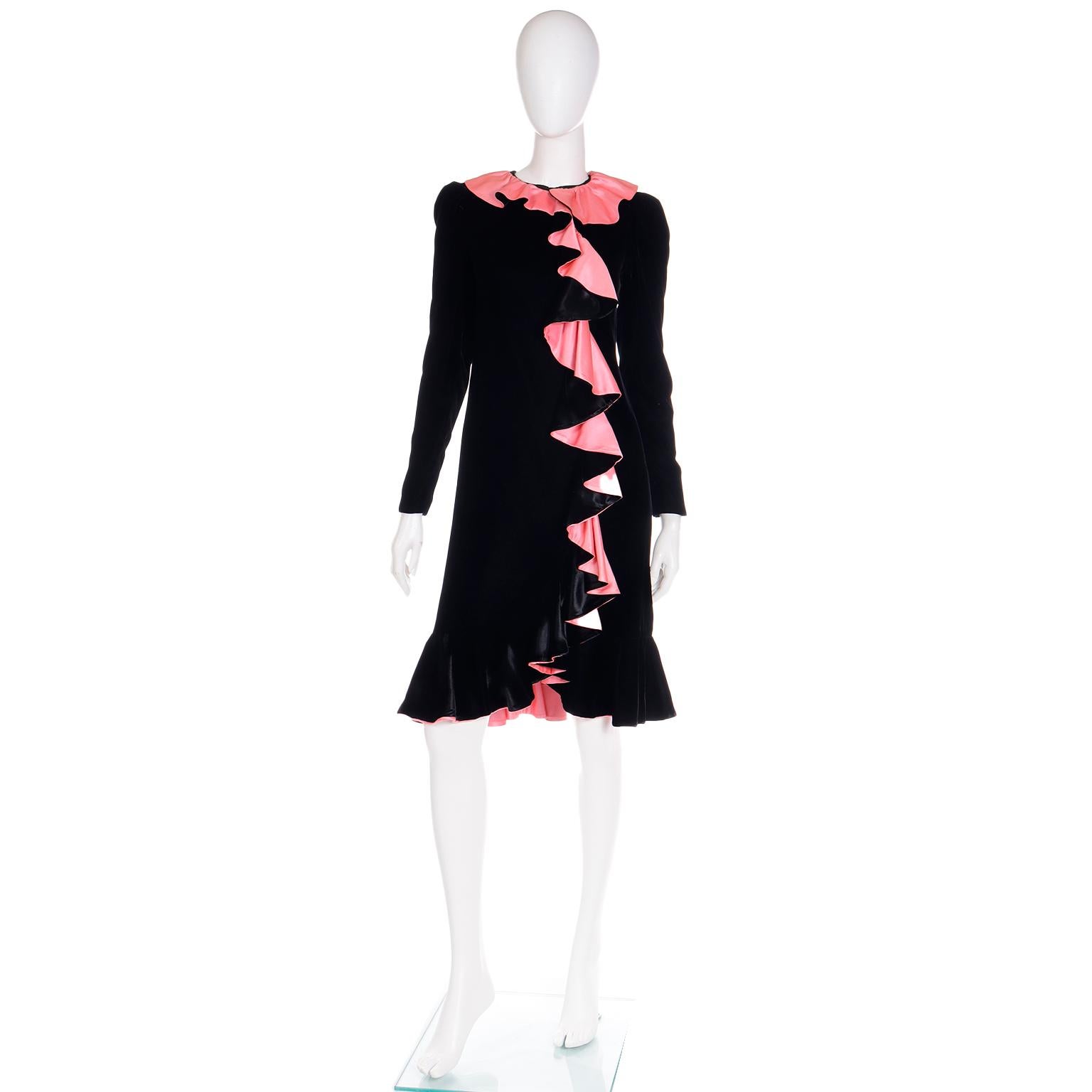 This vintage Oscar de la Renta evening dress is in a luxe black velvet and it is accented with pink satin ruffles at the collar, hem, and down the front. The dress has long sleeves and closes with a back zipper from the collar to the hips with snaps