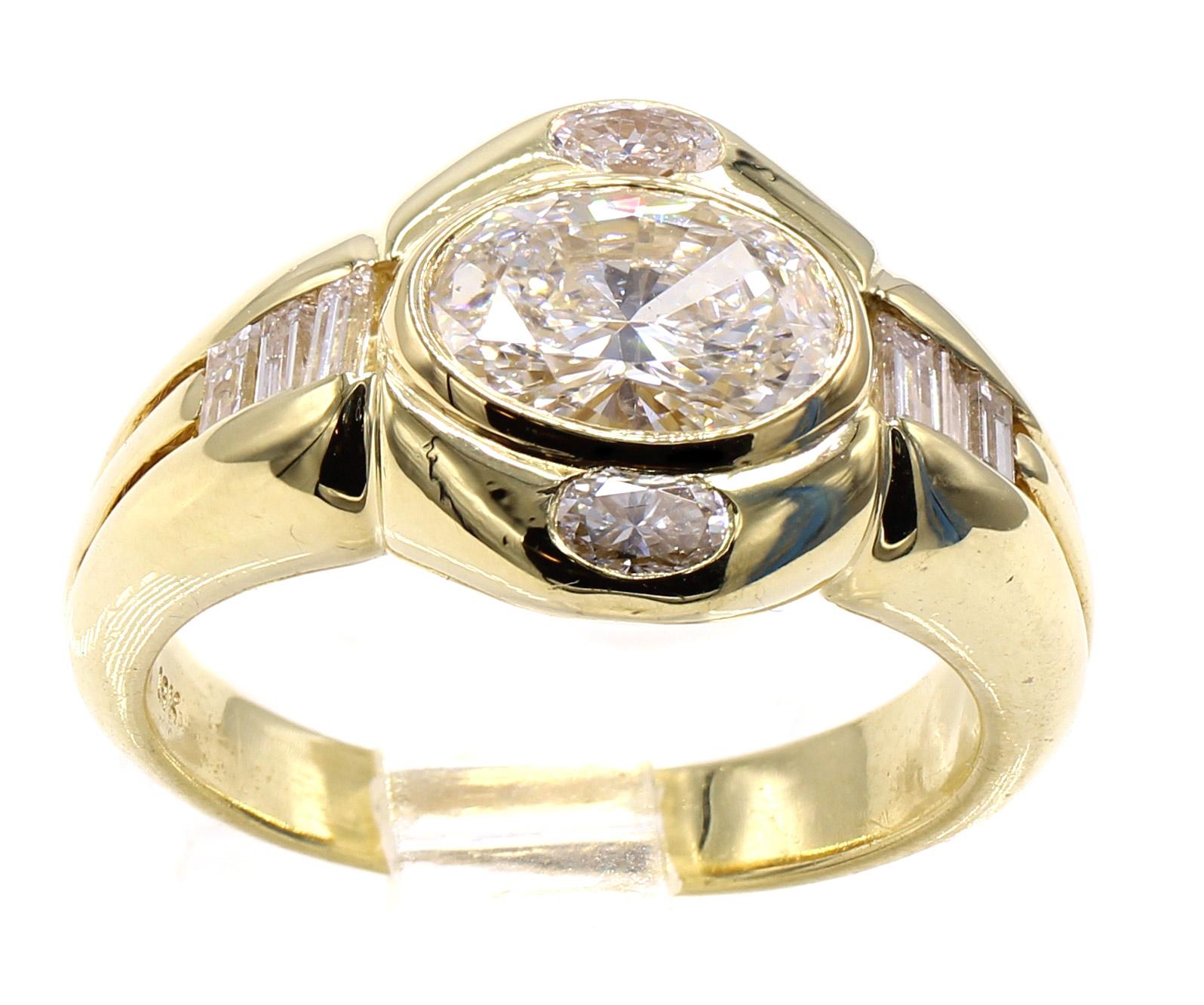 Magnifiquement conçue et réalisée de main de maître en or jaune 18 carats, cette bague présente un diamant central ovale taille brillant pesant 1,02 carats, agrémenté de petits diamants taille ovale d'un côté et de diamants taille baguette de