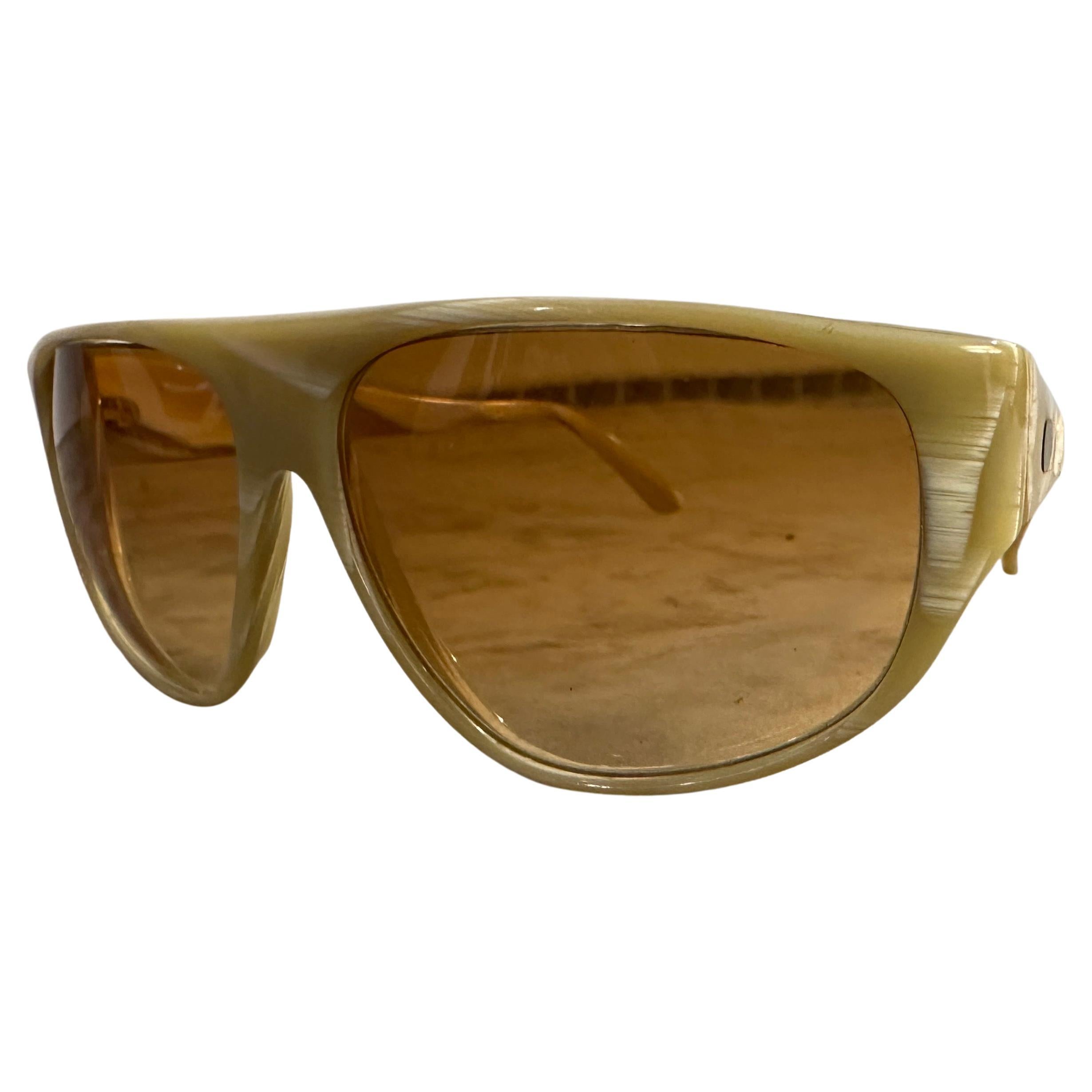 These are a stunning pair of 1980s oversized Italian sunglasses by Valentino, exuding vintage luxury and bold fashion flair.: Made from a high-gloss, marbled acetate in a creamy, light caramel and ivory tone, which gives them a rich, opulent look.