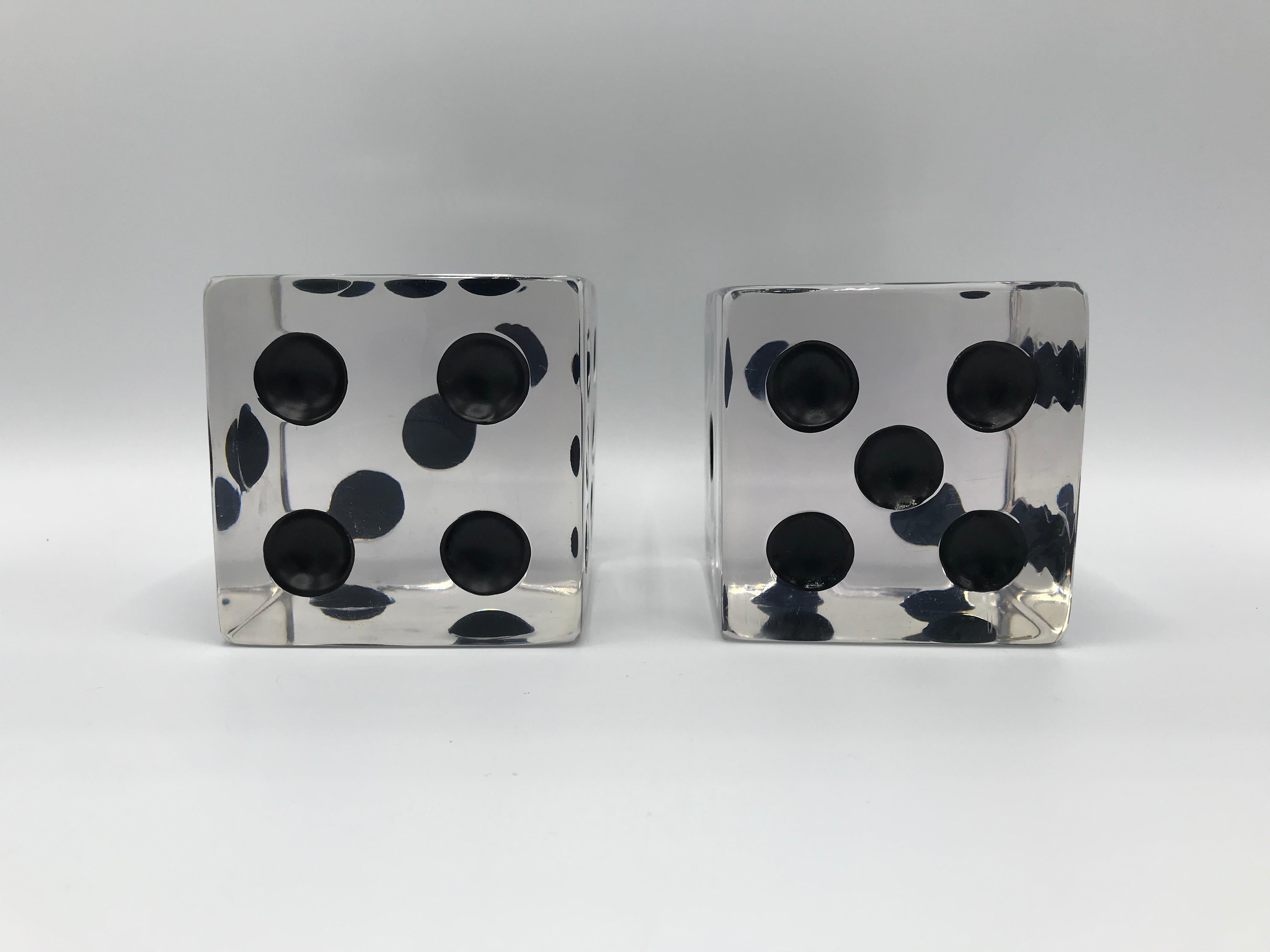 Listed is a fabulous and unique, pair of 1980s oversized Lucite game dice sculptures. The pair would be perfect on any tabletop or shelf. Large enough to be used as bookends. Heavy, weighing 2lbs each.