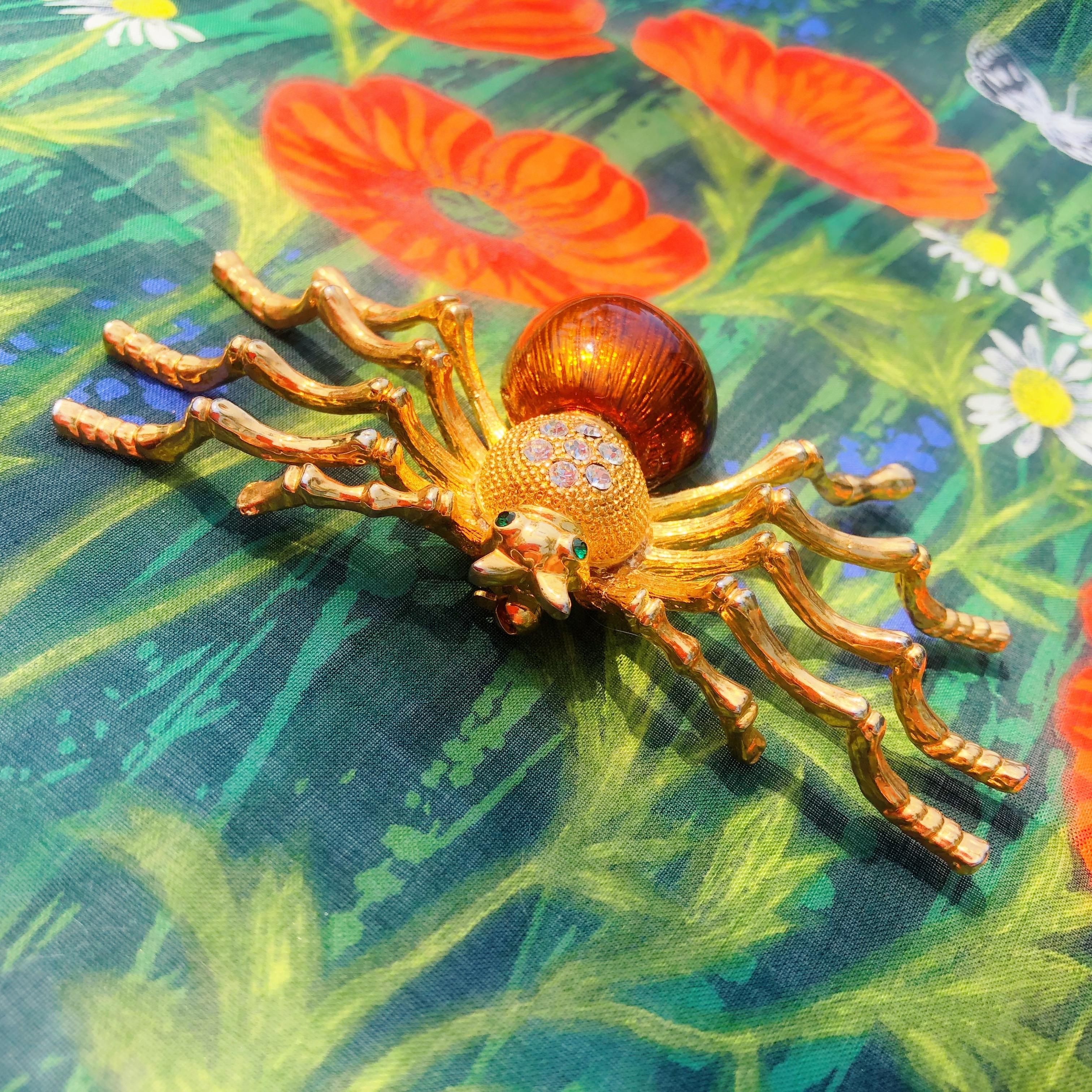Äußerst seltene und außergewöhnliche Fantasie-Brosche mit figuraler Spinne, ca. 1980er Jahre.

DETAILS:
- Vergoldet
- Klare und smaragdfarbene Strasssteine
- Braun emailliert
- 4.5