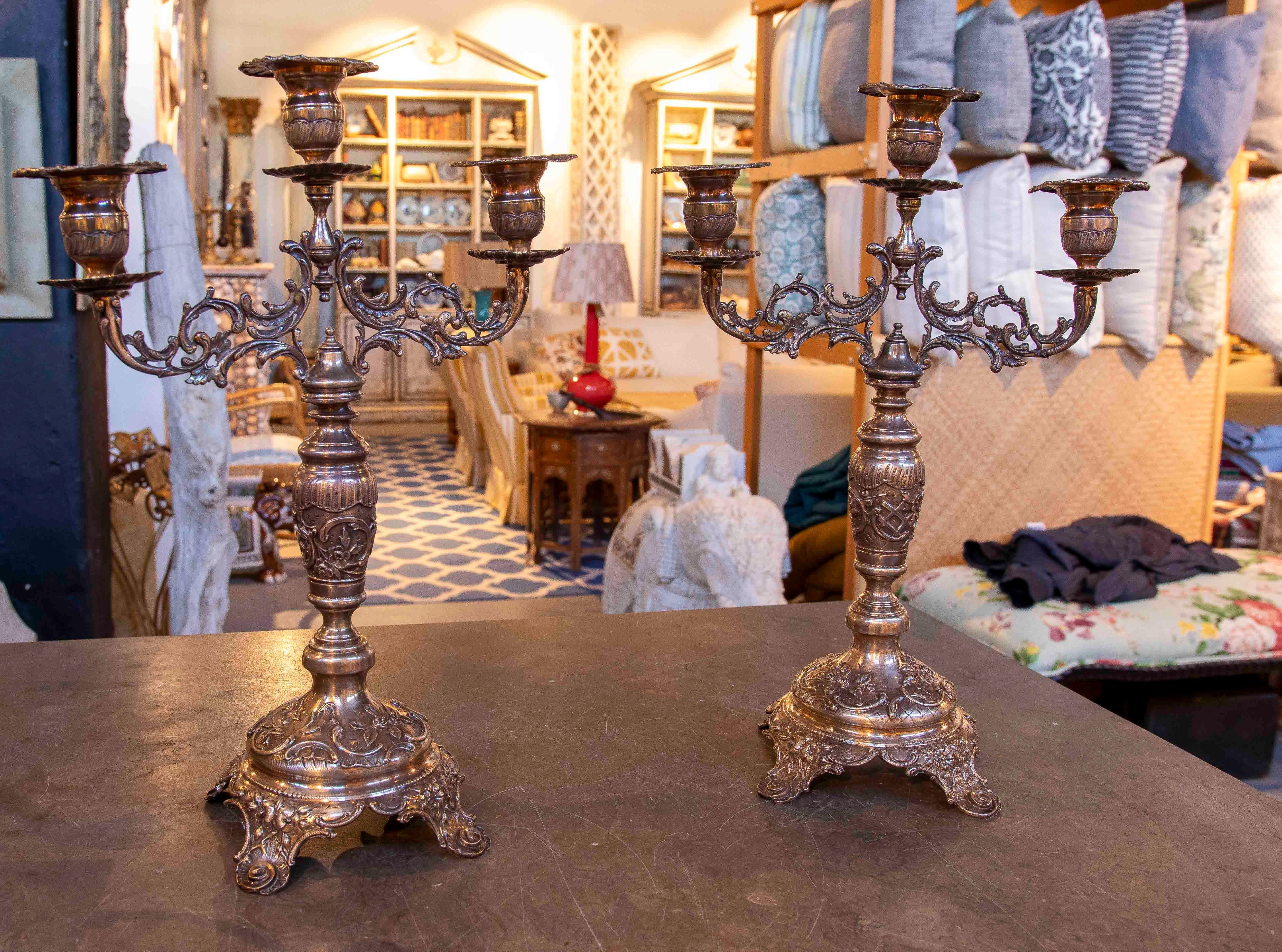 An elegant pair of five-armed candelabras crafted from bronze with a beautiful aged finish that enhances their historical character. They feature fine classical decoration with scrolls and reliefs, typical of 19th-century European style. Their