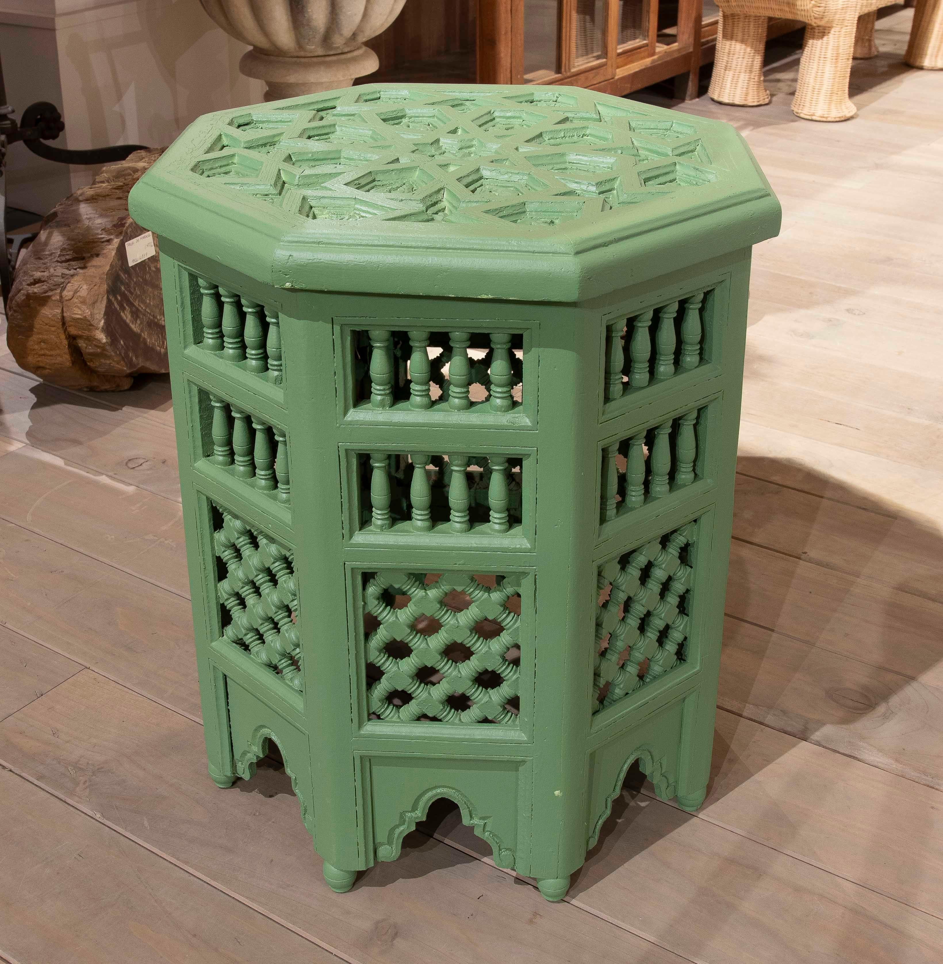 A beautiful pair of carved wooden side tables with intricate Arabic-inspired geometric designs. Painted in a vibrant green colour, these pieces stand out for their octagonal shape and handcrafted details, such as small turned columns and decorative
