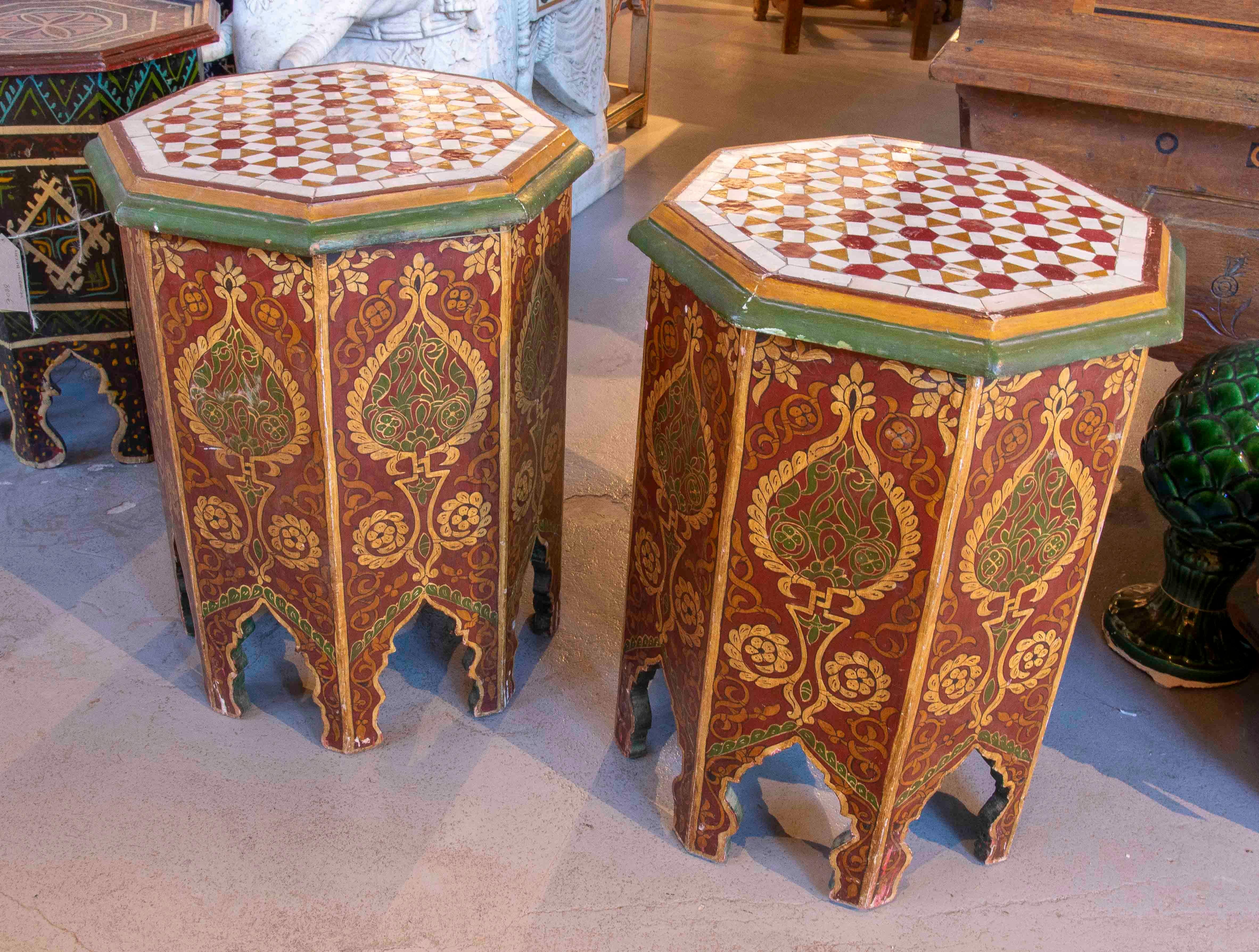 A beautiful pair of Moroccan-style side tables with an octagonal frame and exquisite hand-painted craftsmanship. The sides feature floral and geometric motifs in shades of red, green, and gold, creating a vibrant and traditional decorative effect.