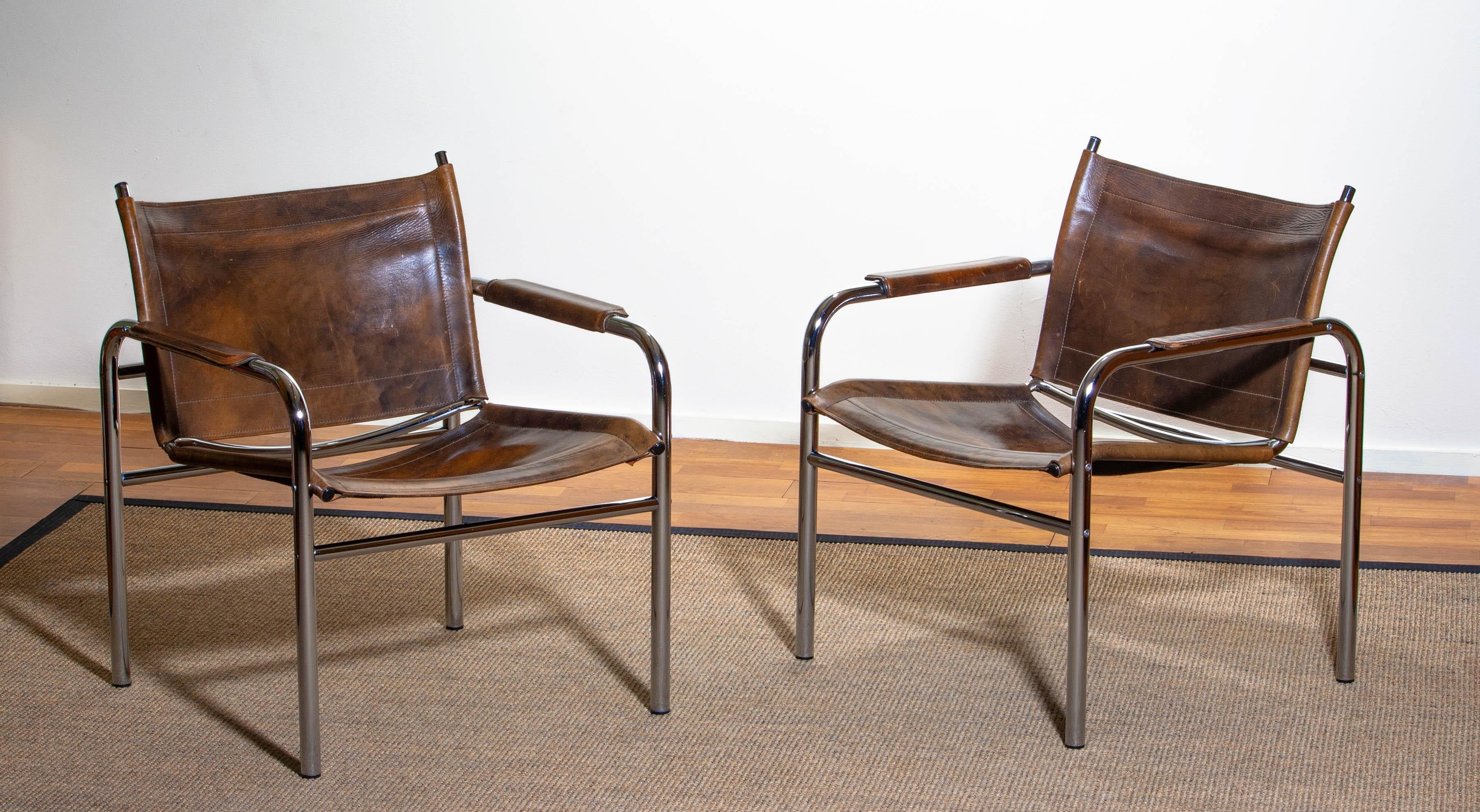 Beautiful pair of armchairs, model Klinte, designed by Tord Björklund, Sweden. The chairs having a tubular chromed steel frame with brown-taupe leather back / seating and armrest with a beautiful patina. 
Period 1980.
 