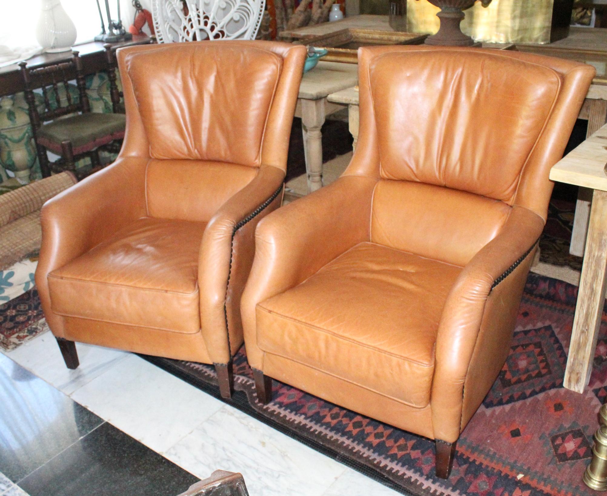 paire de fauteuils espagnols des années 1980 en cuir, en très bon état, avec des pieds en bois et des punaises décoratives.