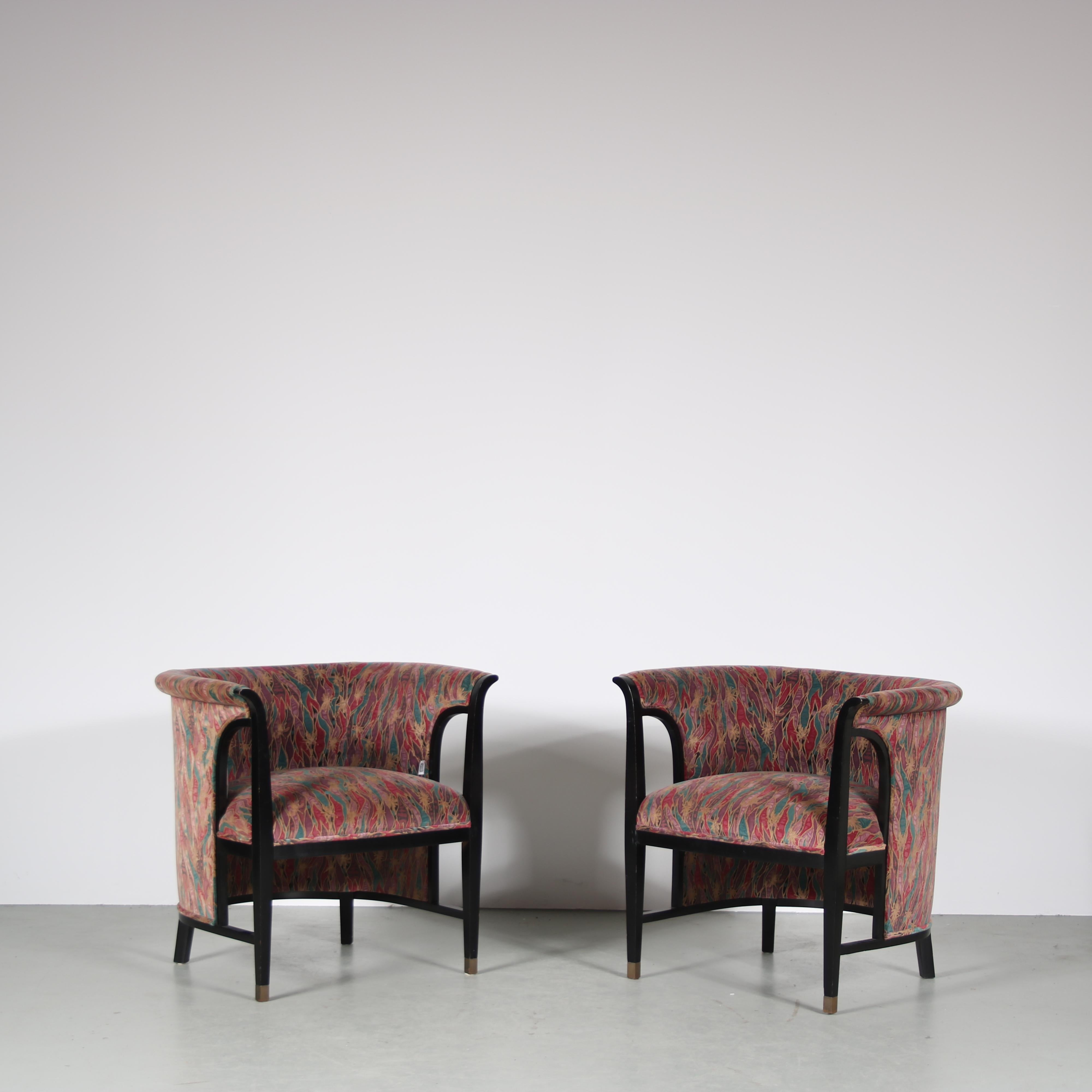 A unique pair of easy chairs designed and manufactured by Selva in Italy during the 1980s.

These chairs feature black wooden frames that have a very appealing, modern look with a touch of Art Deco. The leg ends have golden coloured details. The