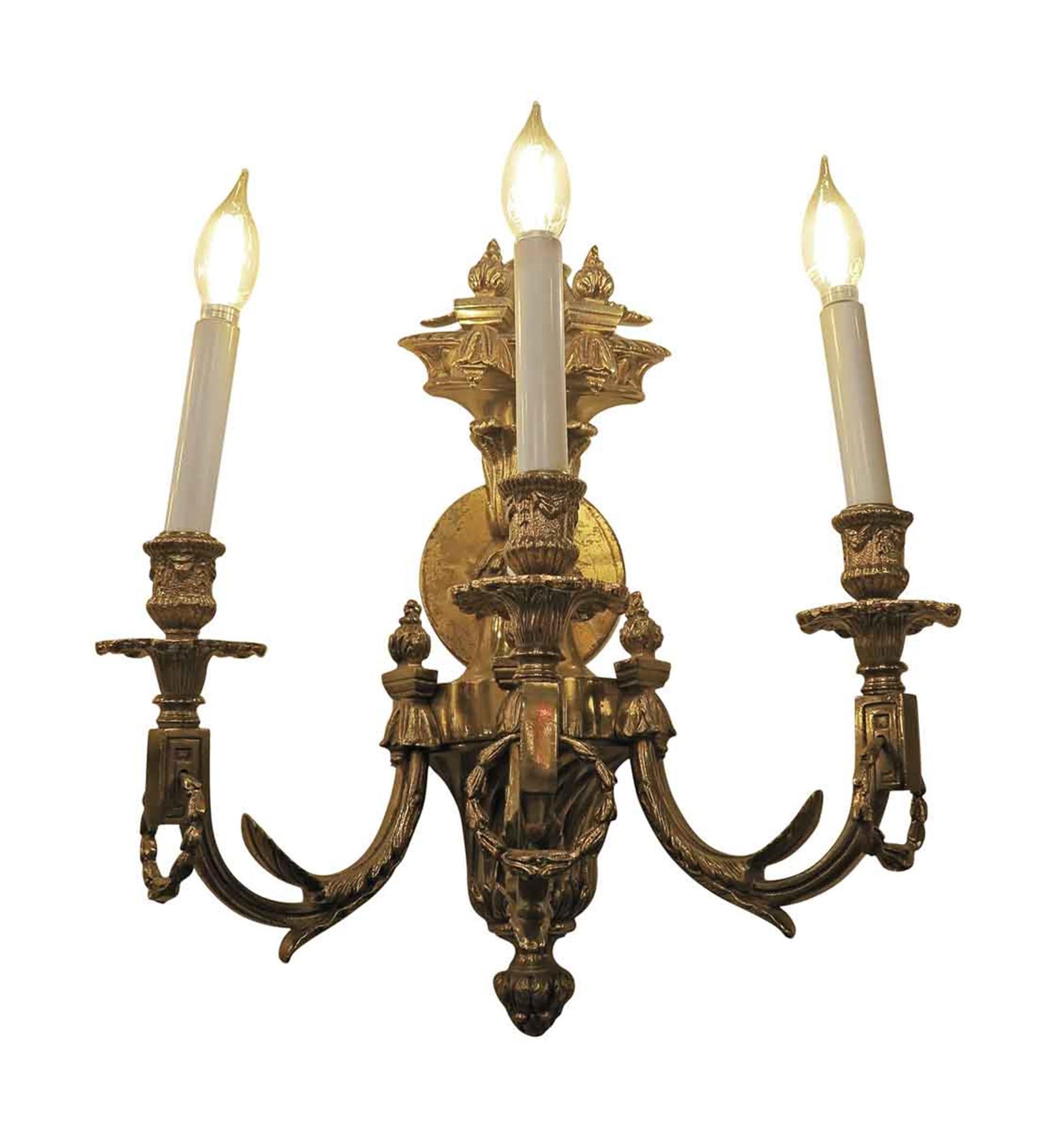 Heavy cast bronze triple arm sconces from Conrad suite foyer in the Waldorf Astoria Hotel. These sconces cast in the Empire style with ornate details were installed in the Conrad suite during the extensive renovation to the hotel in the 1980s. These