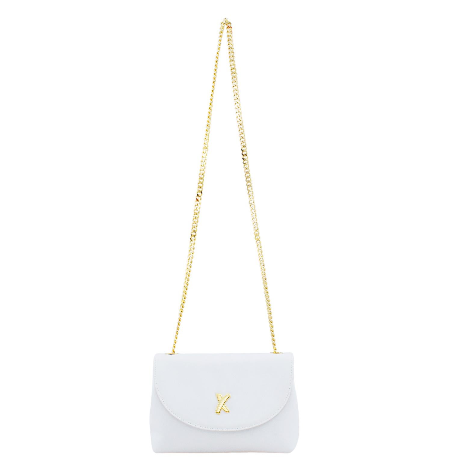 Petit sac en cuir blanc Paloma Piccaso des années 1980. La quincaillerie dorée et la chaîne très importante de 21 pouces pour l'épaule et le corps contrastent brillamment avec le cuir blanc. logo 'X' sur le devant. Rabat en forme de demi-lune qui se