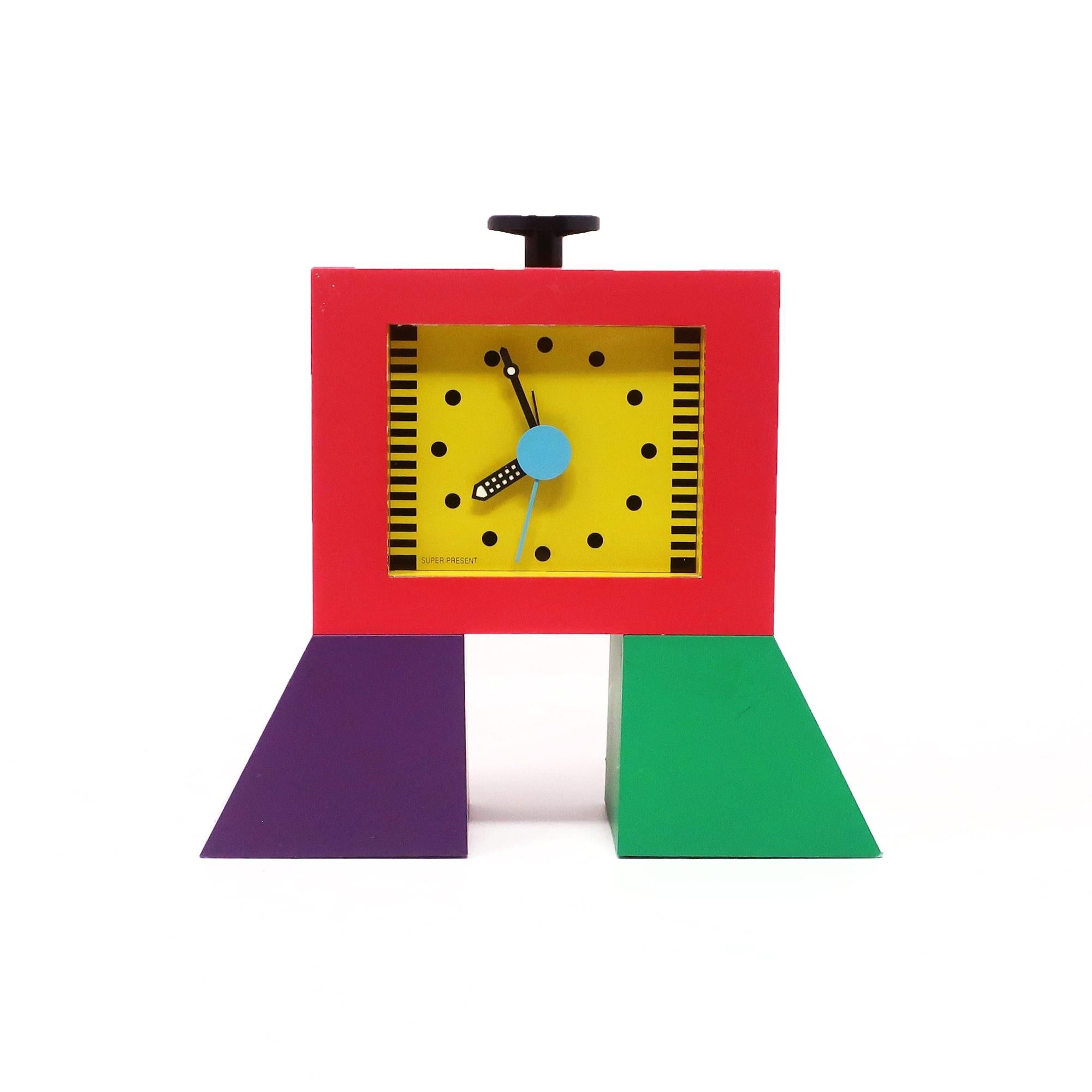 Une horloge de bureau, de cheminée ou d'étagère postmoderne parfaitement conçue par Shohei Mihara pour la collection Super Present de Wakita.   Boîtier en plastique vert, violet et rouge, cadran jaune avec marketing noir et alarme start/stop noire