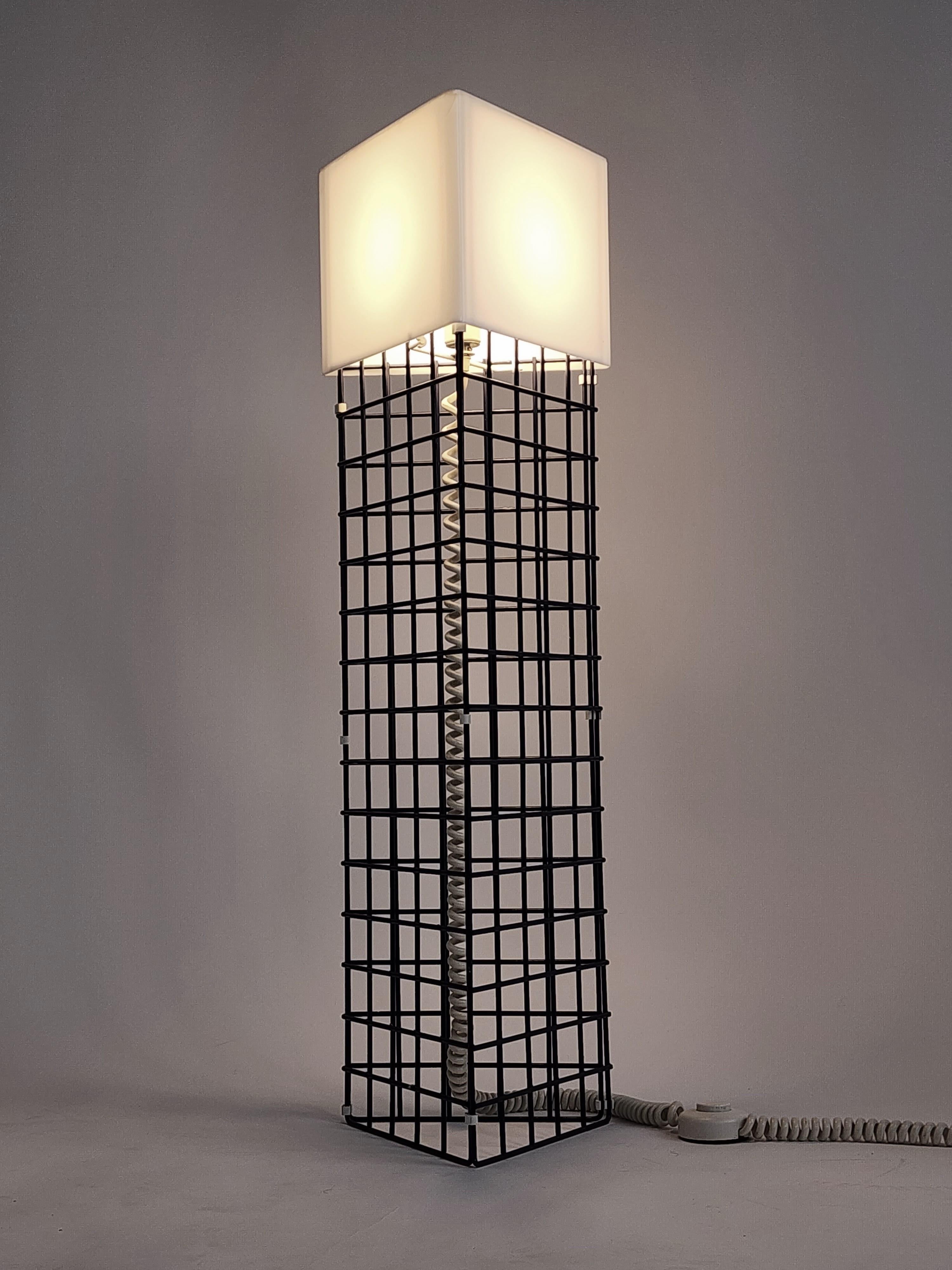 Opale acrylic shade sitting on a architectural grid floor lamp, powder coated in a dark blue tone. 

One E26 ceramic socket rated at 60 watt. 

Foot switch on cord.