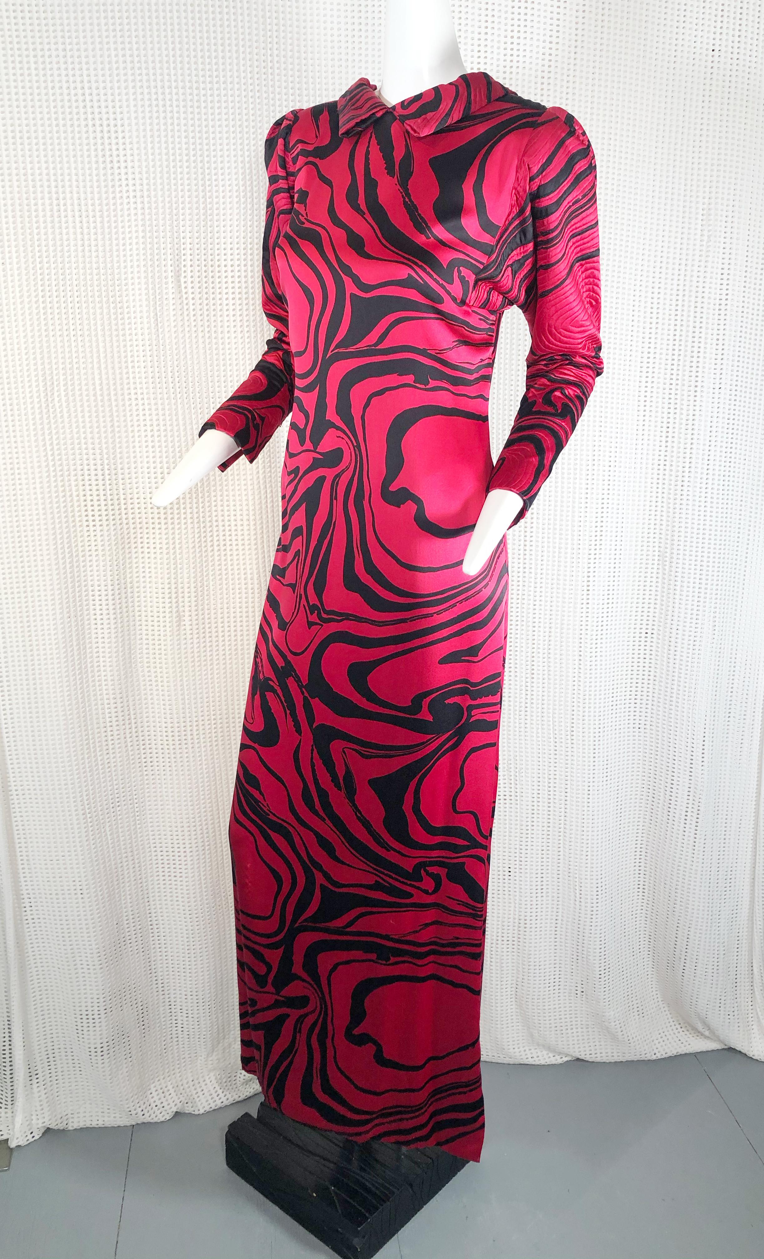 A wonderful design by Pauline Trigere in a marbleized silk charmeuse print with a low back and criss cross strap design. Features include quilted puff shoulders and tapered sleeves.

High quilted collar that folds low to the back. 

Gown is