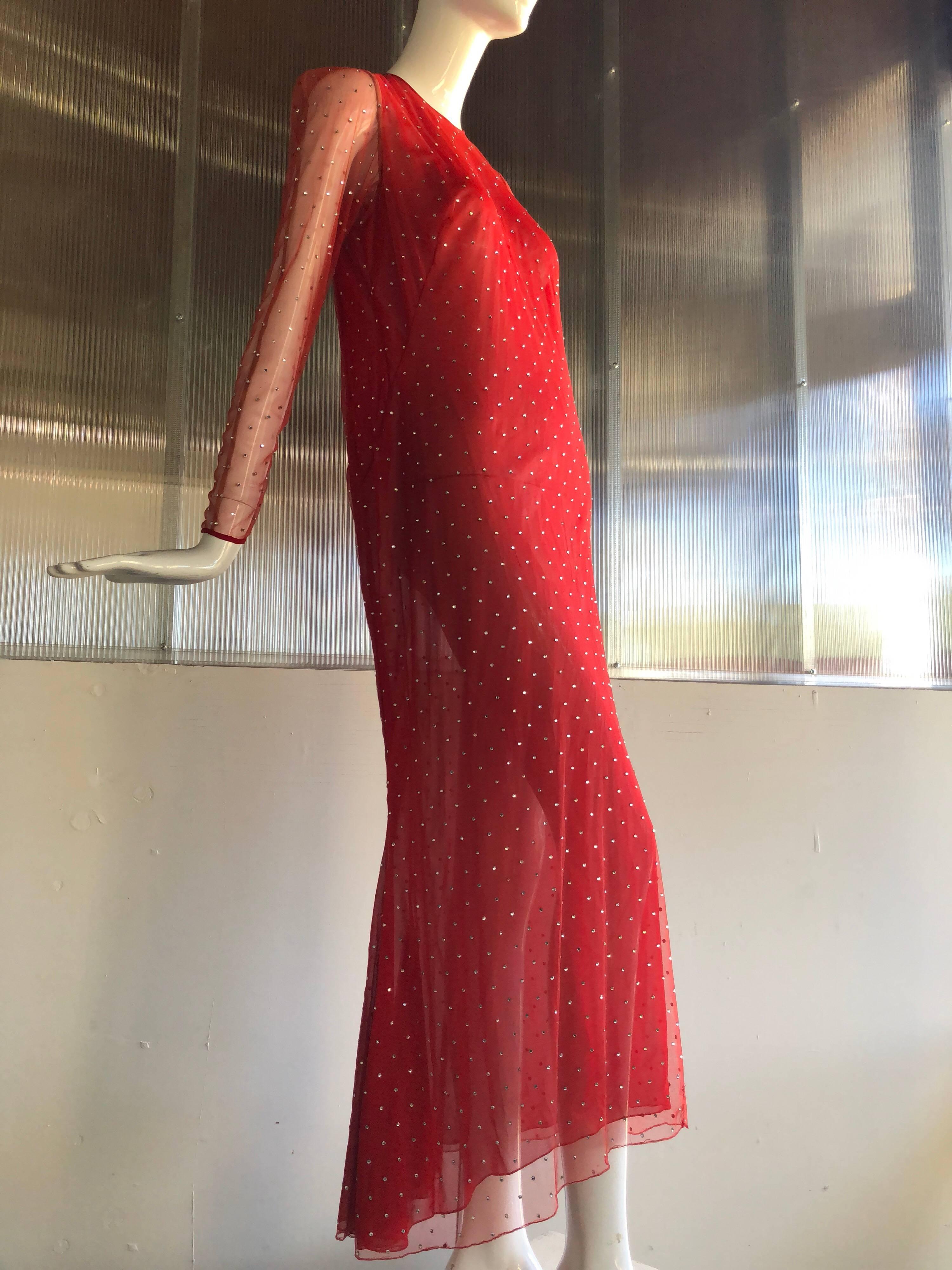 This classic and signature Red by Pauline Trigere net gown is completely studded with rhinestones! 
Featuring long sheer sleeves that button at the wrist and zips up the back. This silhouette reminiscent of a 1930s design is slightly on the bias and
