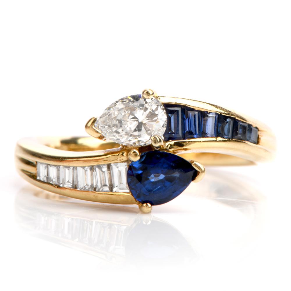 A twist in style yet still asymmetrical.

This lovely and delicate engagement ring was inspired in an

almost identical bypass design and crafted in 18K yellow gold.

The top of the ring features both a pear shaped, transparent cornflower blue