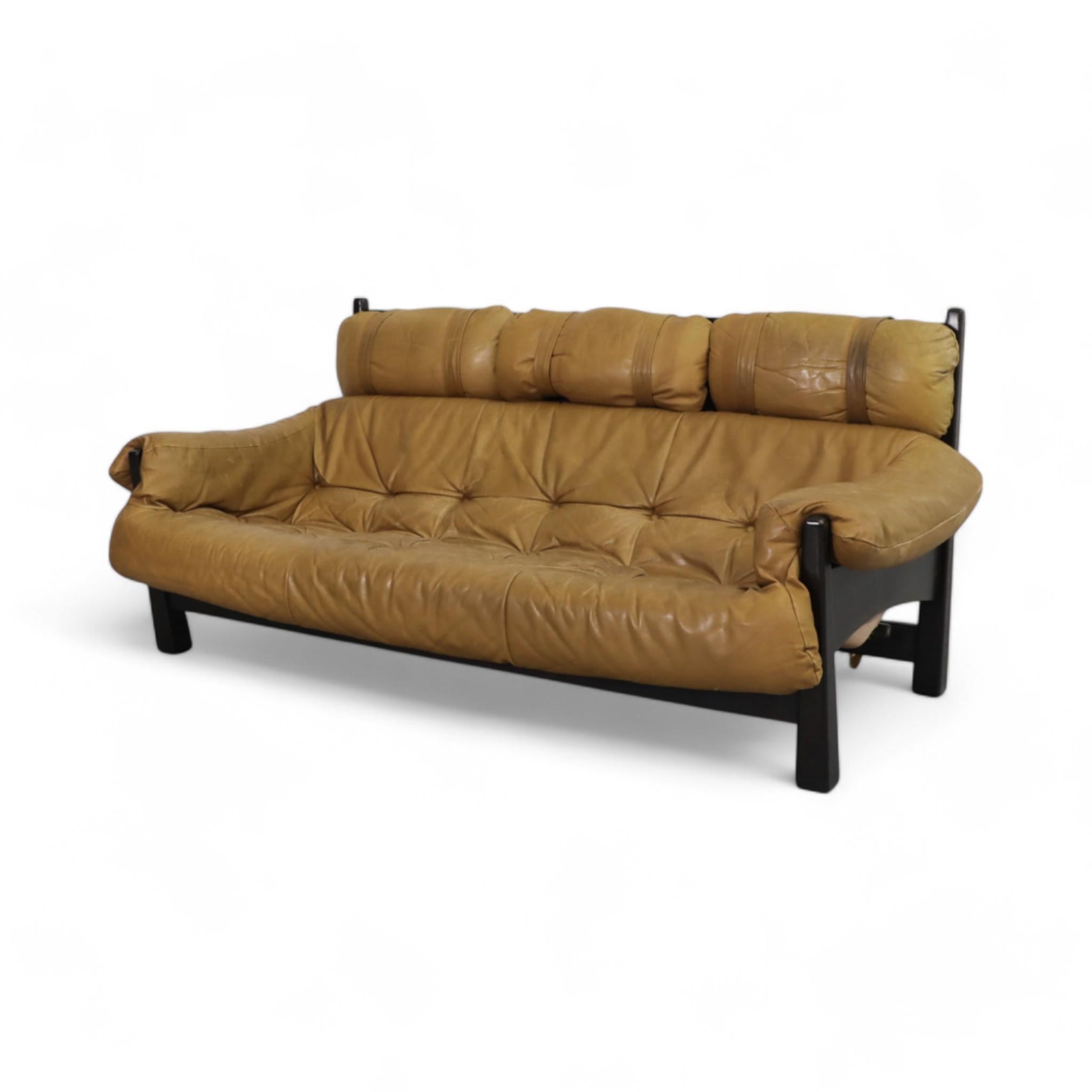 1980s Percival Lafer style leather sofa, designed by Gerard Van Den Berg for Montis, embodies vintage charm with its tufted caramel leather upholstery and striking black wooden frame. Its relaxed silhouette and unique strap details reflect the era's