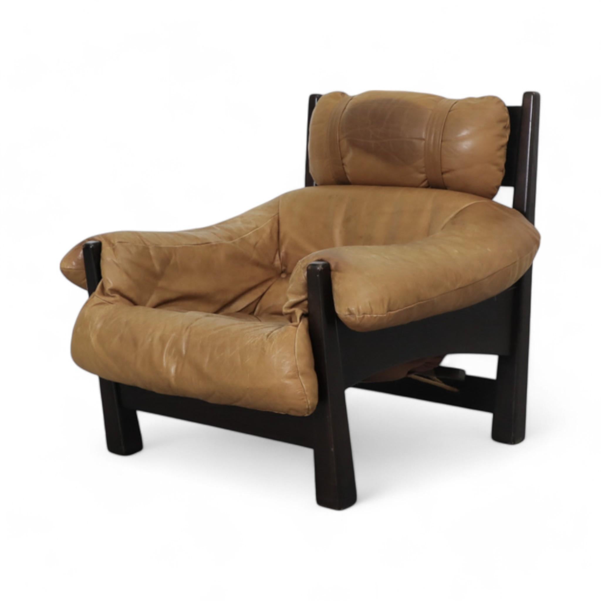1980s Percival Lafer Style lounge chair, designed by Gerard Van Den Berg for Montis, showcases caramel leather upholstery with tufted details and a sturdy black wooden frame. Its inviting design combines timeless comfort with a striking, mid-century