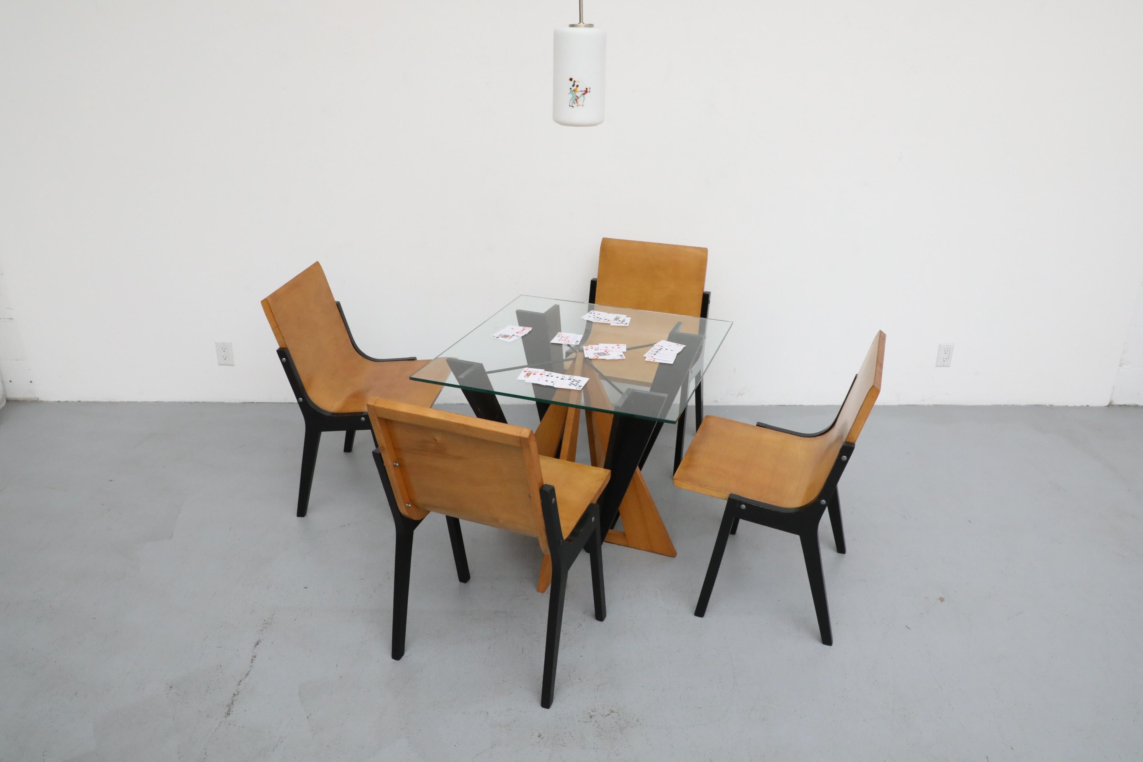 Audacious Memphis style 28-inch glass top dining or center table, designed in the style of Peter Shire. Dates back to the 1980's. The design features geometric, visually interlocking wood shapes that combined, form the base of the table. The Memphis