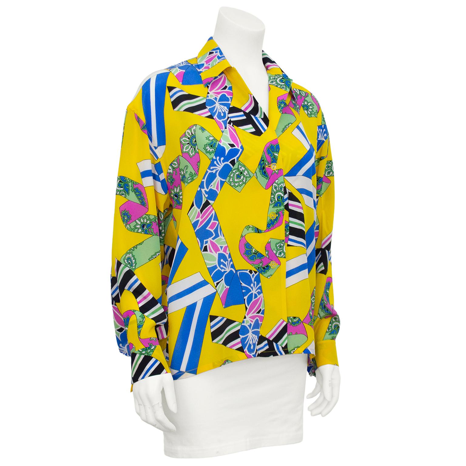 1980s Pierre Balmain blouse. Yellow with the look of four different ribbon patterned silk scarves blowing in the wind. One black with white, pink, blue and green diagonal stripes. The second, blue and white. The third, pink and green paisley. And