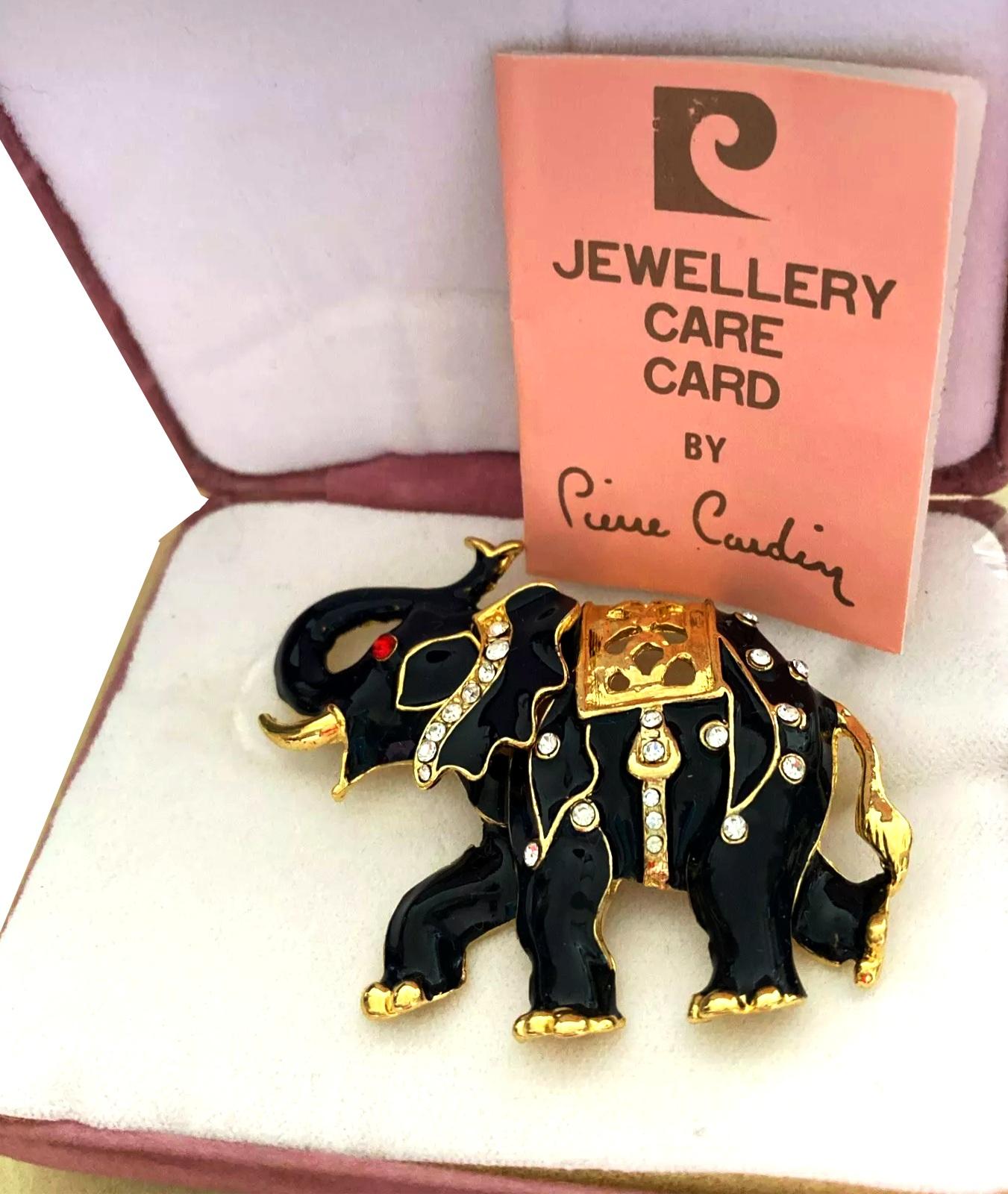 Large Vintage 1980's Pierre Cardin Brooch in a lovely Elephant design, Black Enamel & Gold Tone, Sparkly stones. 

Dimensions: 6x5cm

Condition: 1980s, very good condition in original box, original papers. 