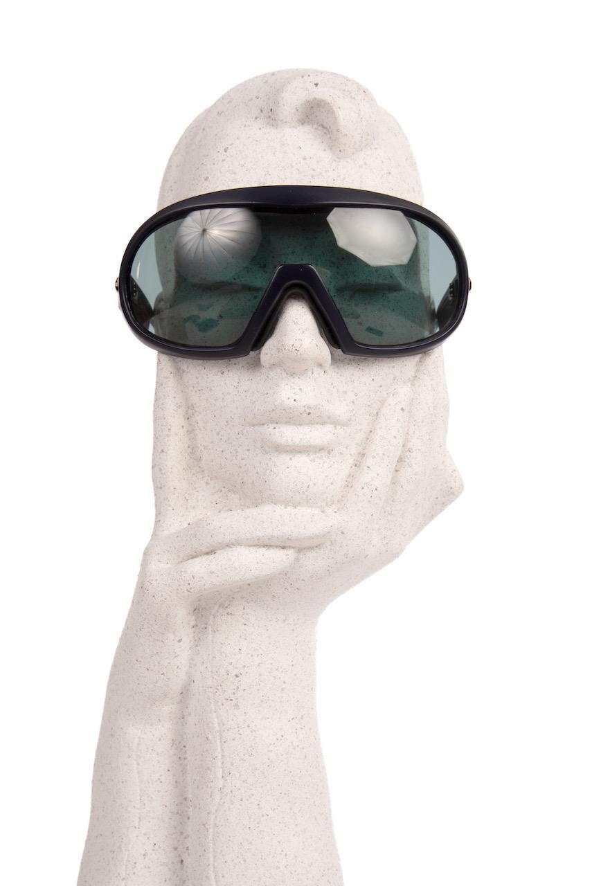 Avantgarde 1980s sporty unisex mask-style model 50/7 Pierre Cardin Paris oversized sunglasses featuring a dark blue frame and light blue lenses.

Manufactured by HCS in Western Germany. Padded leather part inside the frame across the forehead,