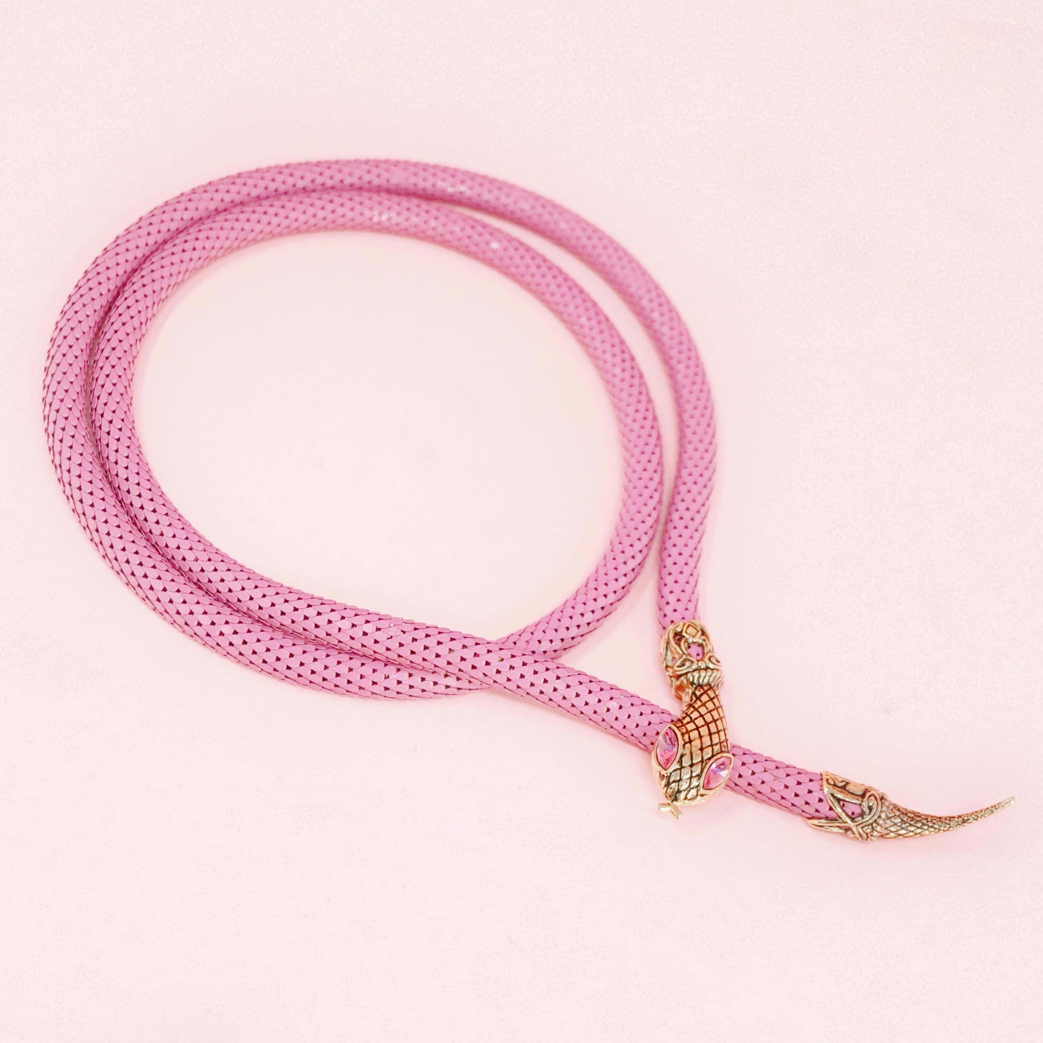 This gorgeous belt, which can also be worn as a necklace, is constructed of an innovative pink powder coated mesh material with gold tone snake head and tail embellishments.  The snake head possesses matching pink rhinestones with intricate