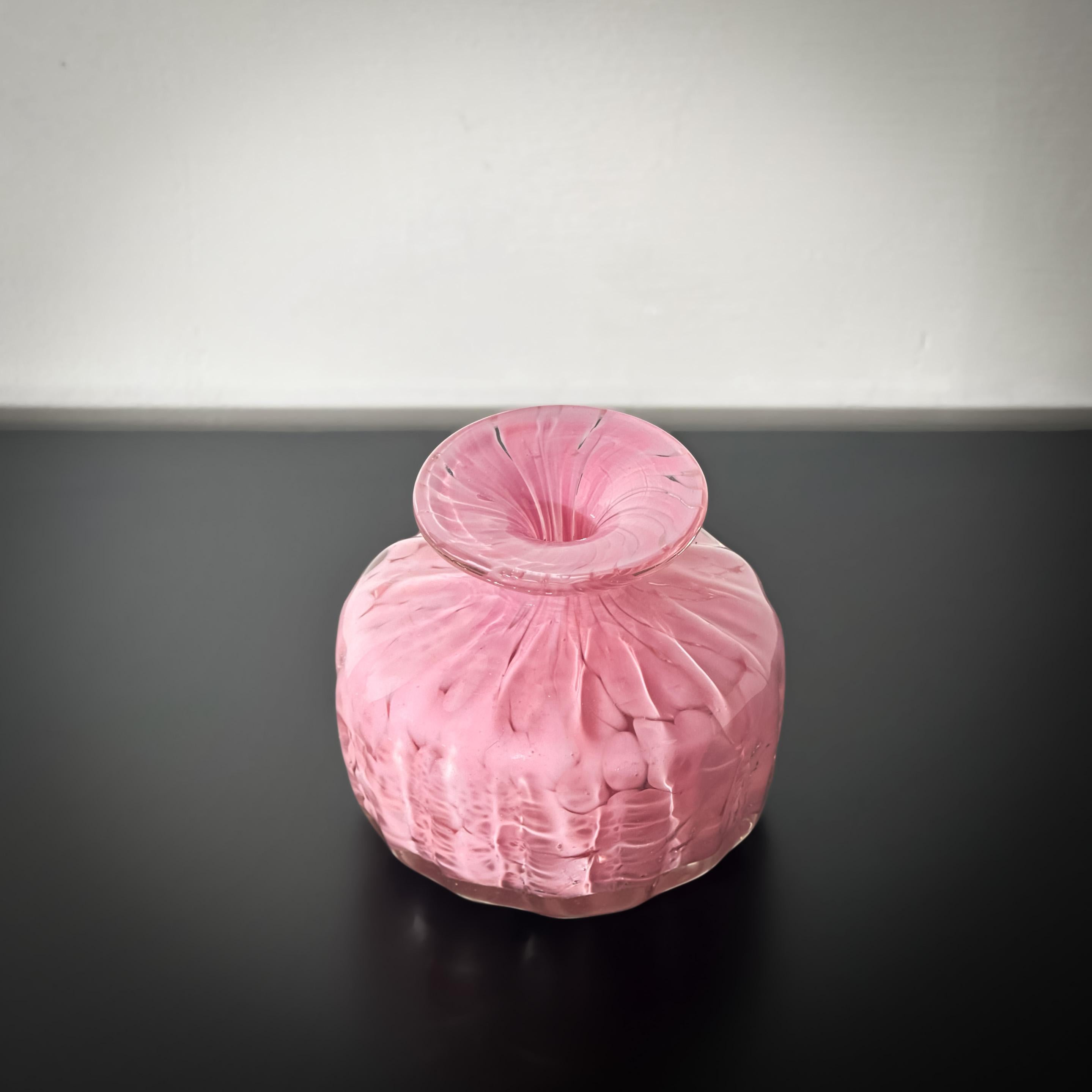 Une petite bouteille trapue, un vase en verre, fabriqué dans les années 1980 par Mdina Glass. 

Réalisée en verre opaque rose avec des taches de verre clair tacheté, cette bouteille décorative présente un extérieur cannelé avec des crêtes