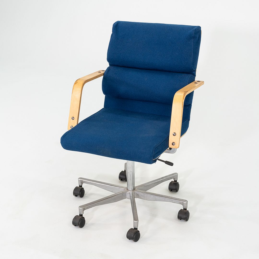 This is a Plaano Chair, originally designed by Yrjo Kukkapuro in 1974. This particular example was produced by Avarte in Finland circa the 1980s. The chair is comprised of a steel 5-star base, a seat upholstered in blue fabric, and birch armrests. 
