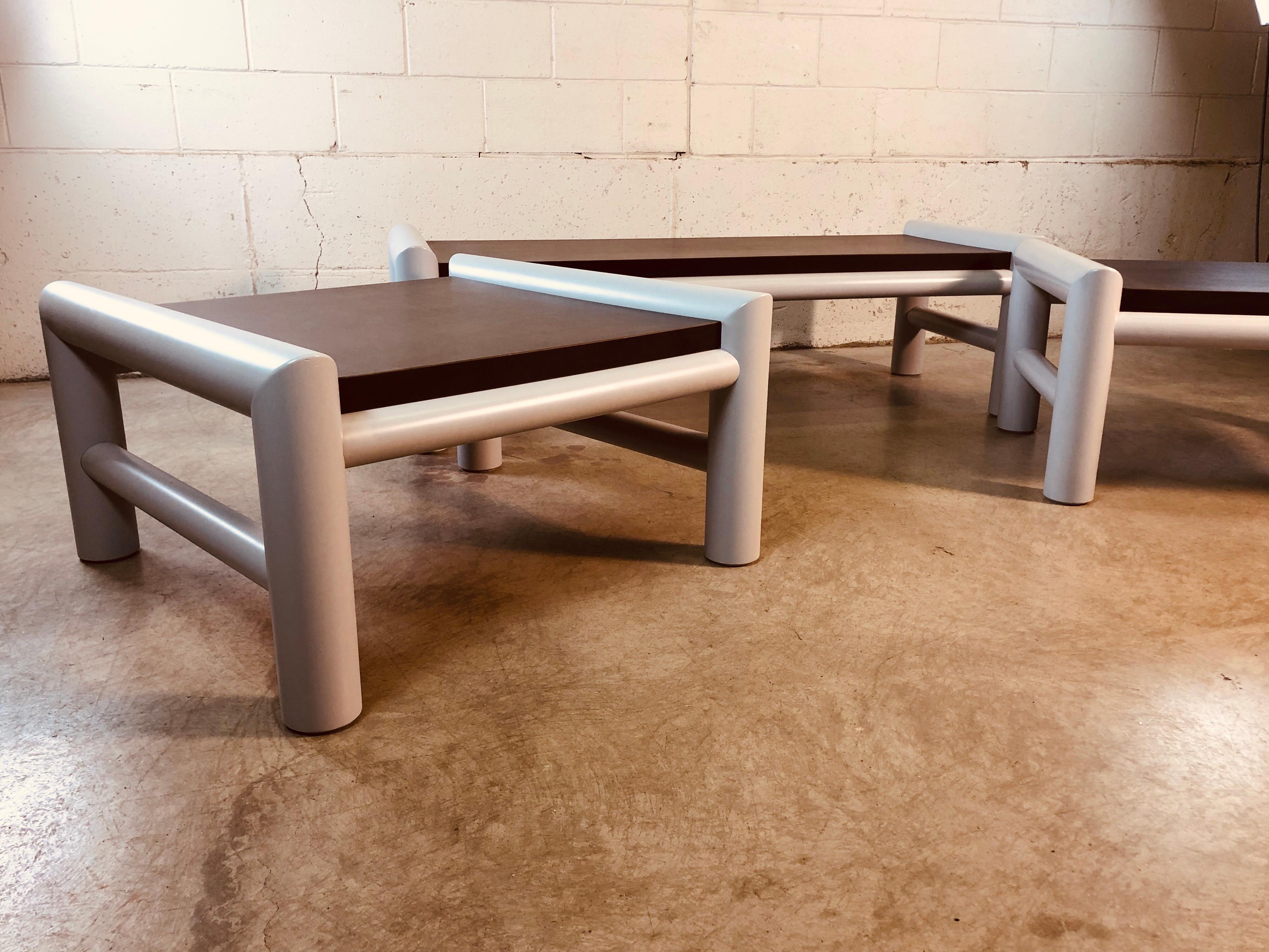 1980s set of 3 indoor or outdoor plastic table set. The set includes the coffee table, large square side table and smaller rectangular side table. The frames are plastic and the tops are MDF. The tables have all been sanded, painted and restored. No