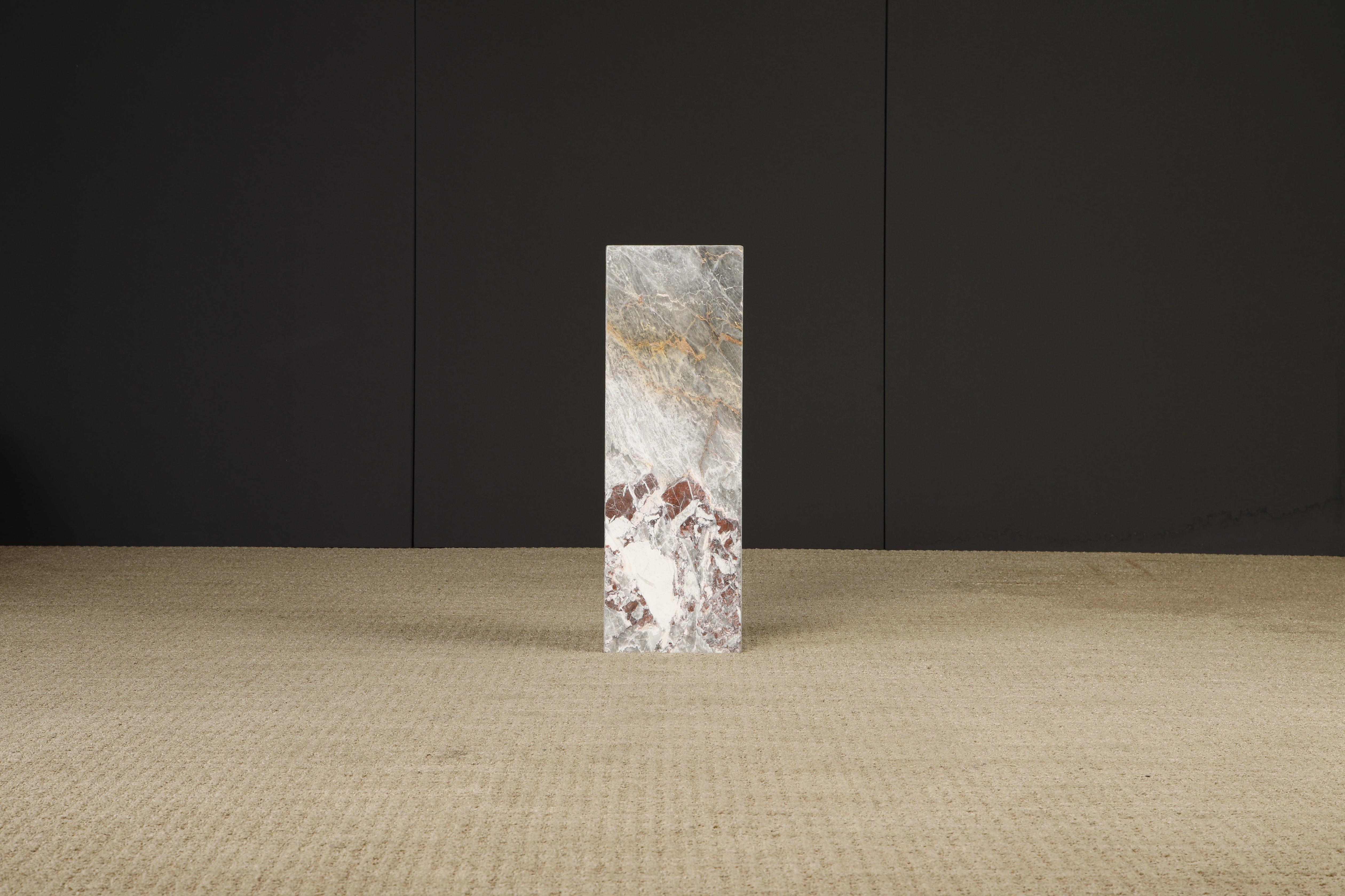 This beautiful 1980s Post-Modern exotic marble column pedestal features exotic graining and coloration with hues of grey, pink, red and gold. 

We have a matching pedestal that is slightly shorter at 25.5