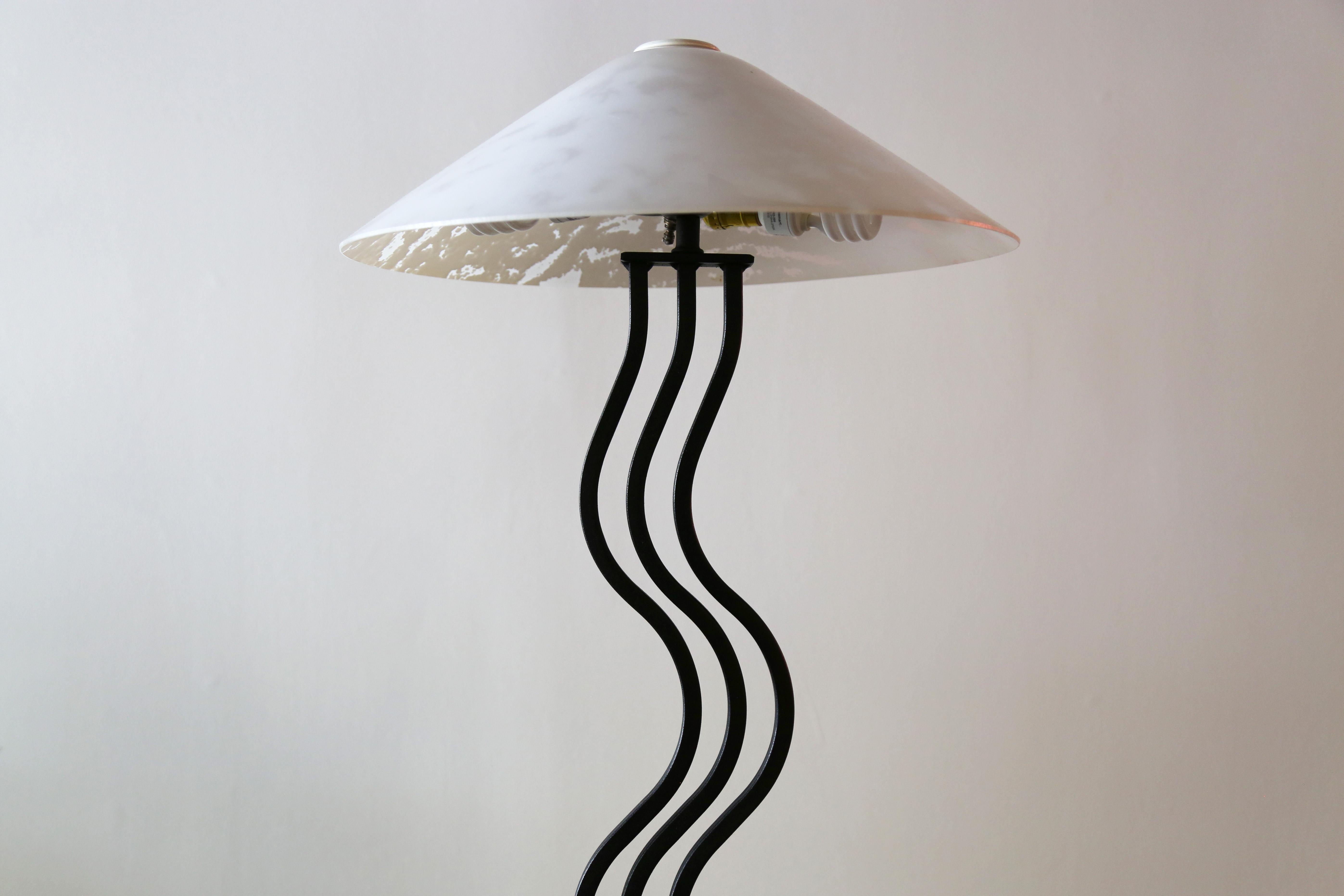 A 1980's postmodern highly sought after vintage Memphis style squiggle floor lamp. Adds the perfect vibe to any room. Its sculptural design features a series of curved metal tubular bars in a powder coated matte black finish. Paired with its