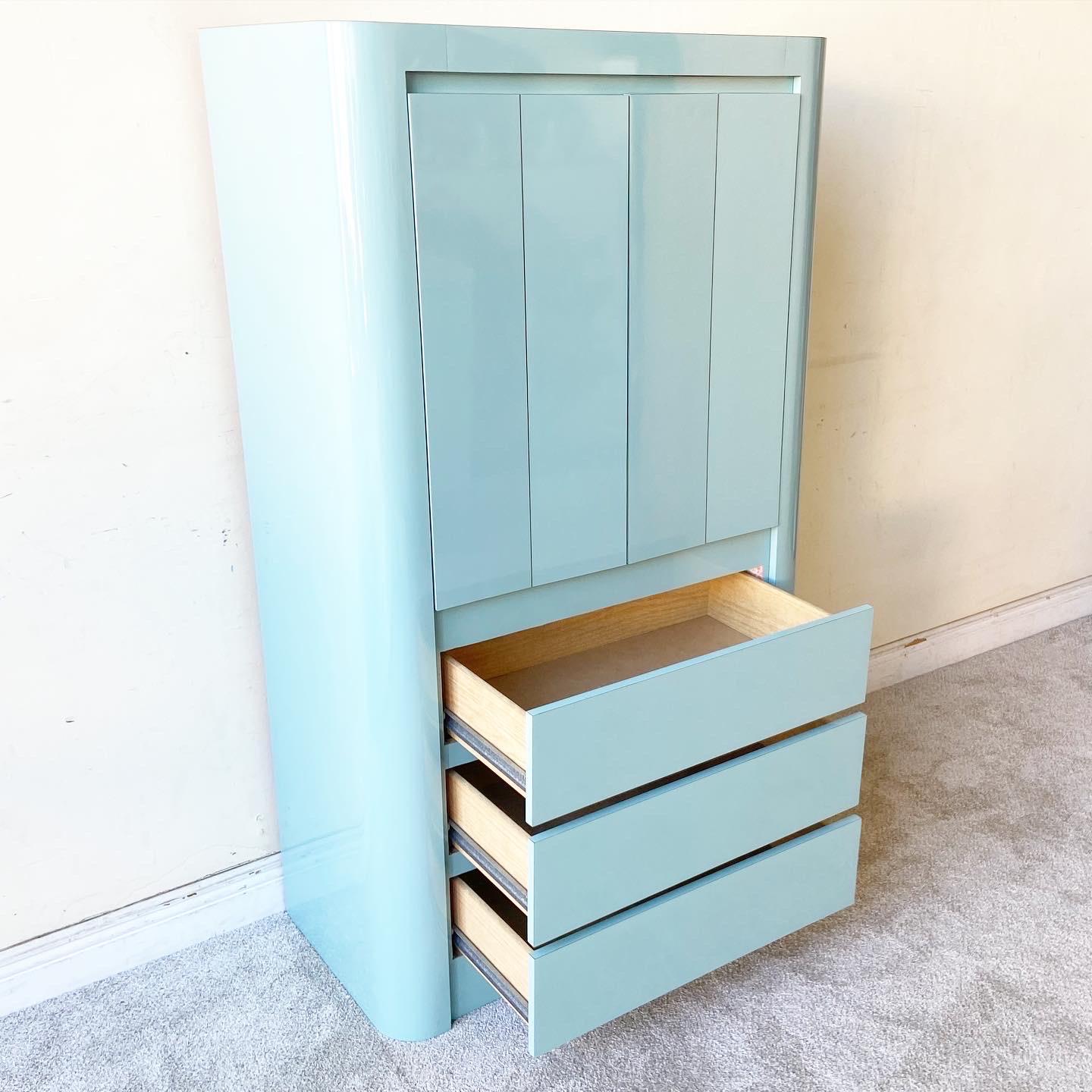 Amazing vintage 1980s postmodern armoire. Features an aqua blue lacquer laminate with a large shelves storage space and 3 spacious drawers.